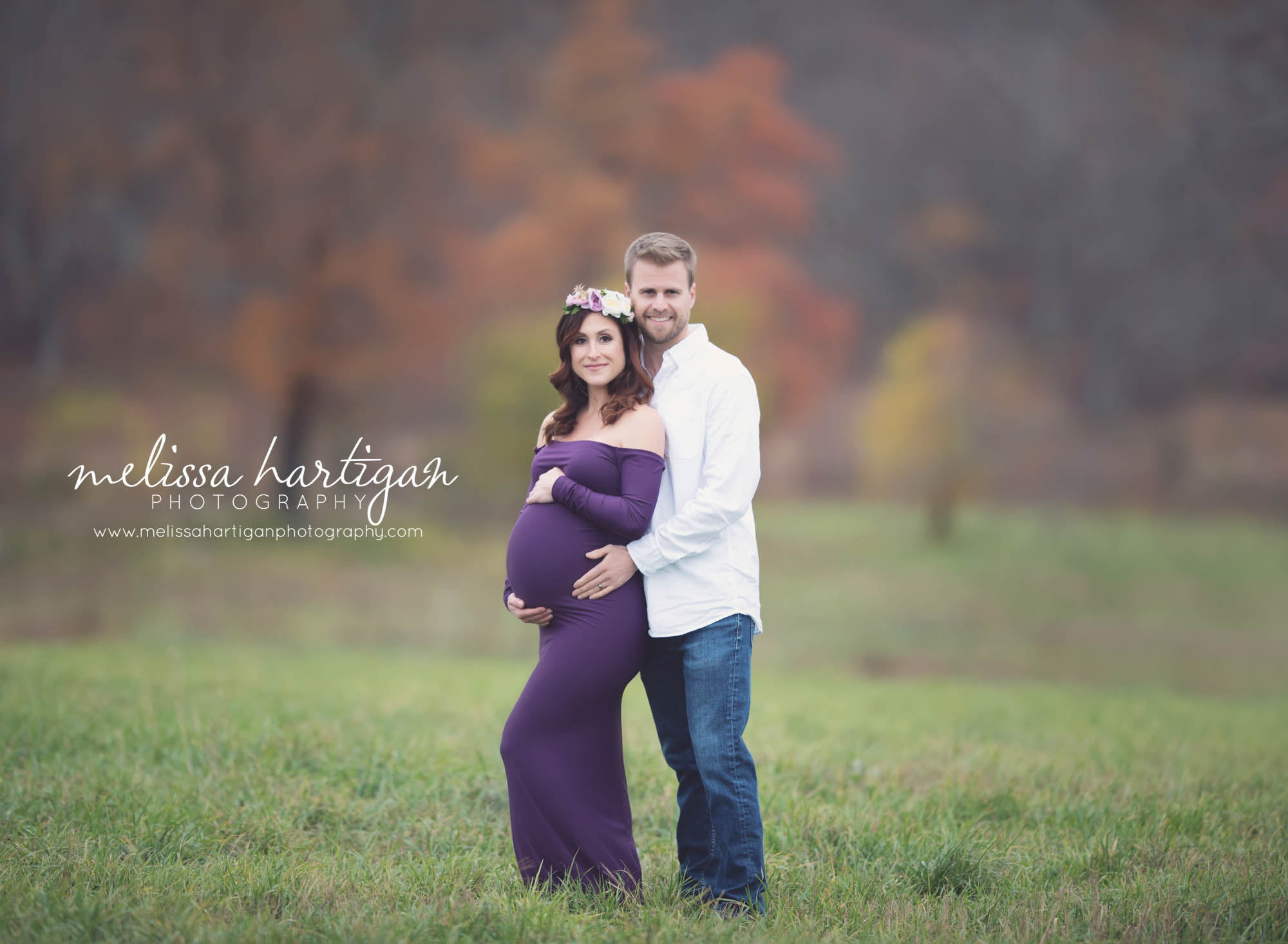 Melissa Hartigan Photography Coventry CT Newborn & Maternity Photographer Coventry CT Maternity Newborn Session Carrie wearing purple maternity gown and floral crown standing in field holding baby bump with husband