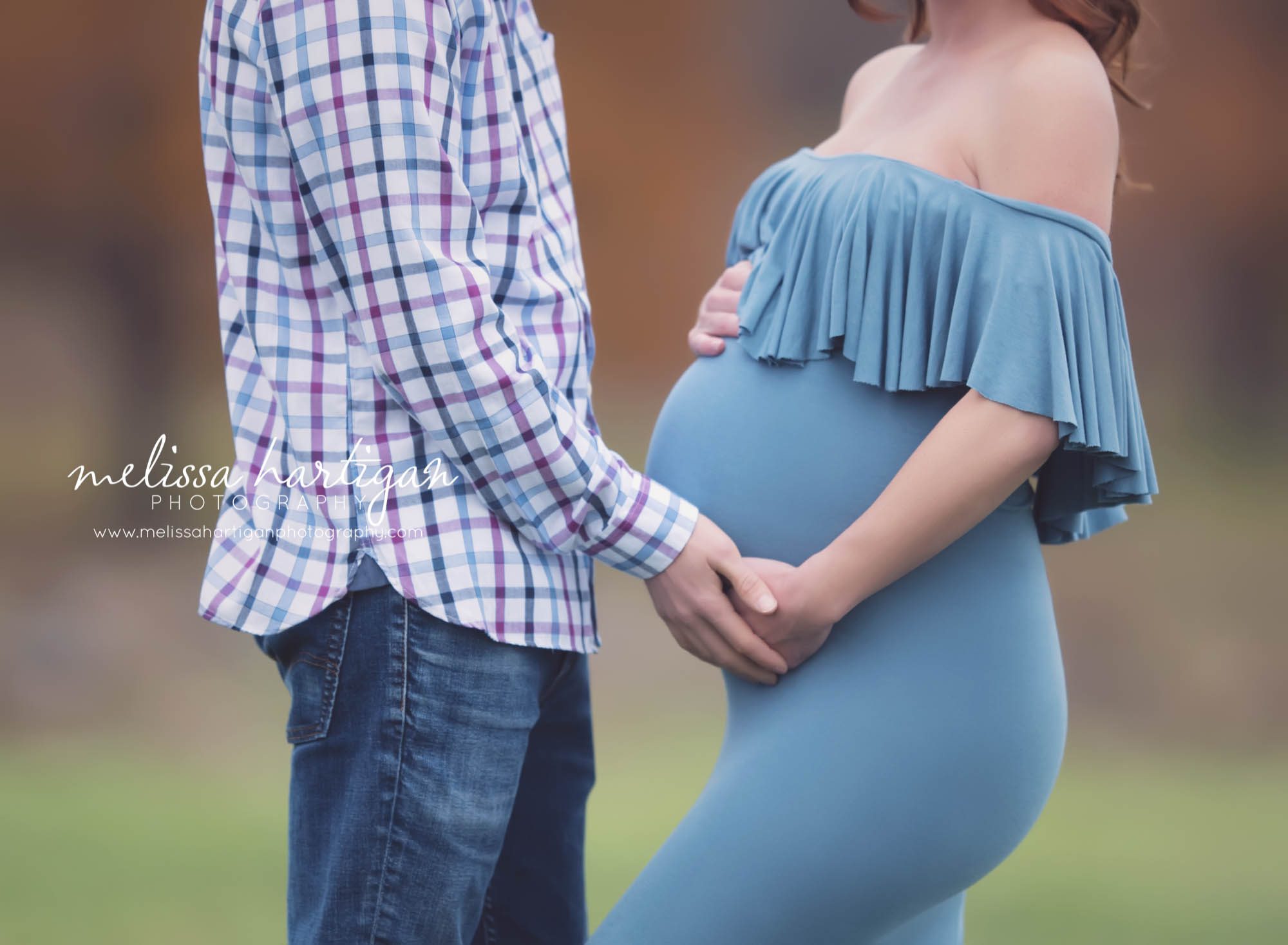 Melissa Hartigan Photography Coventry CT Newborn & Maternity Photographer Coventry CT Maternity Newborn Session Carrie wearing blue maternity gown standing in field holding baby bump with husband close up