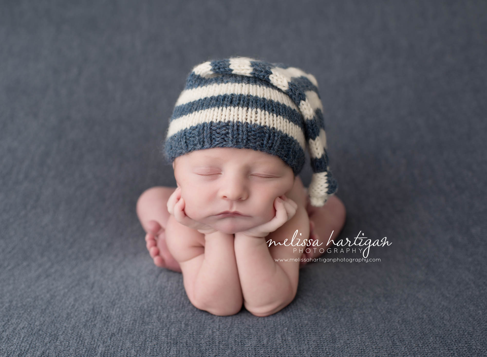 Melissa Hartigan Photography Coventry CT Newborn & Maternity Photographer Coventry CT Maternity Newborn Session Chase wearing striped blue and cream knit hat in froggy pose