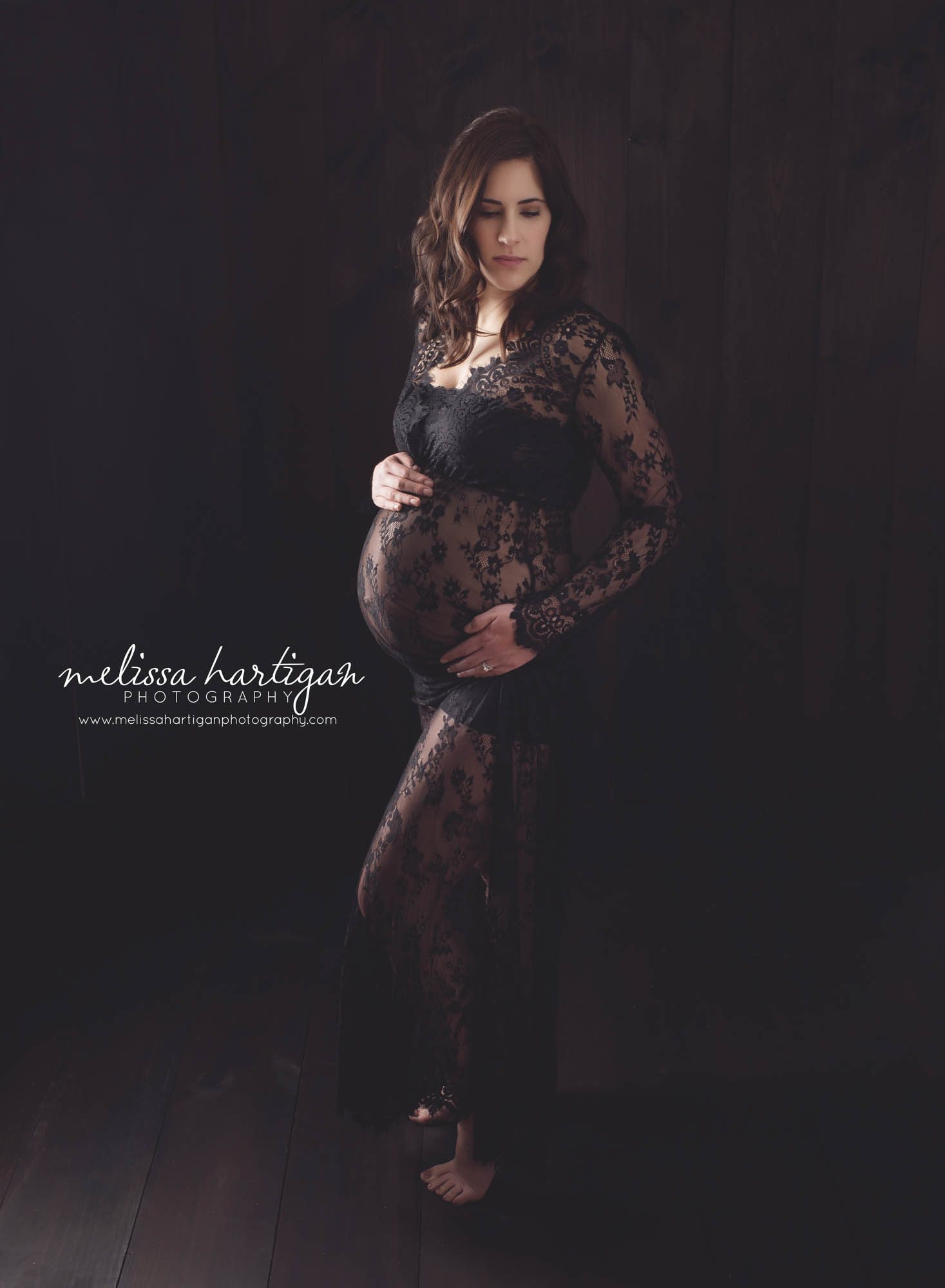 Melissa Hartigan Photography Connecticut Best Maternity Photographer in CT Coventry Ct Middlefield CT baby Fairfield county Newborn and maternity CT photographer Maternity photographer Mommy-to-be indoor session wearing black lace dress standing in front of dark wooden backdrop