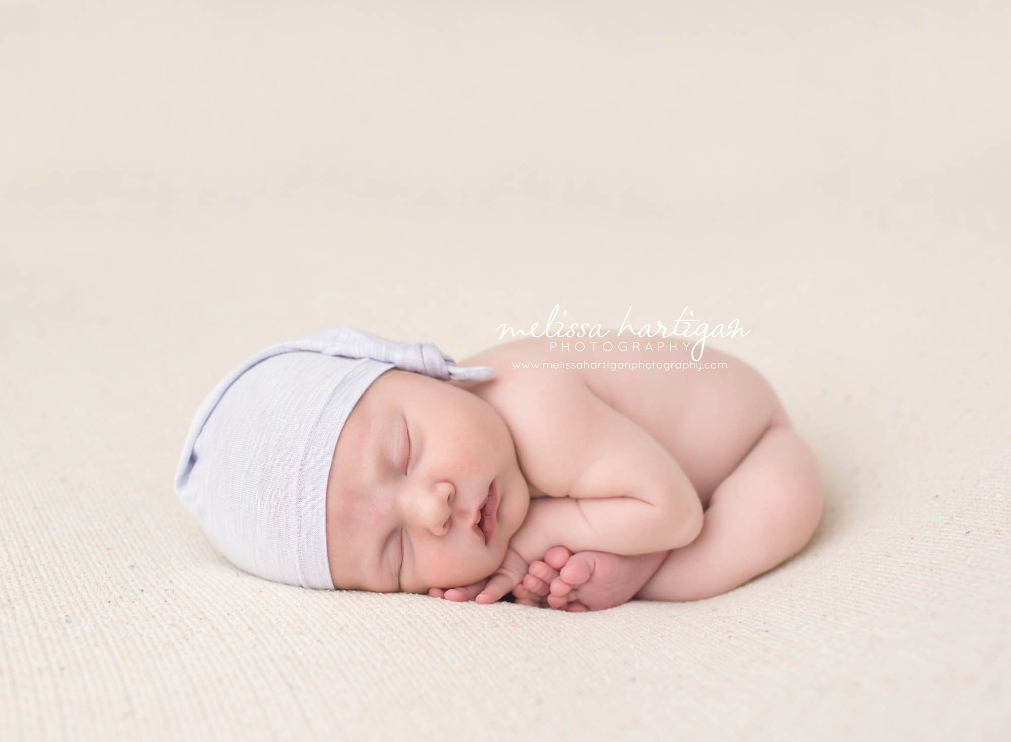 Melissa Hartigan Photography Connecticut Newborn Photographer Coventry Ct Middlefield CT baby Fairfield county Baby girl blue knit cap on pale pink blanket sleeping CT newborn session
