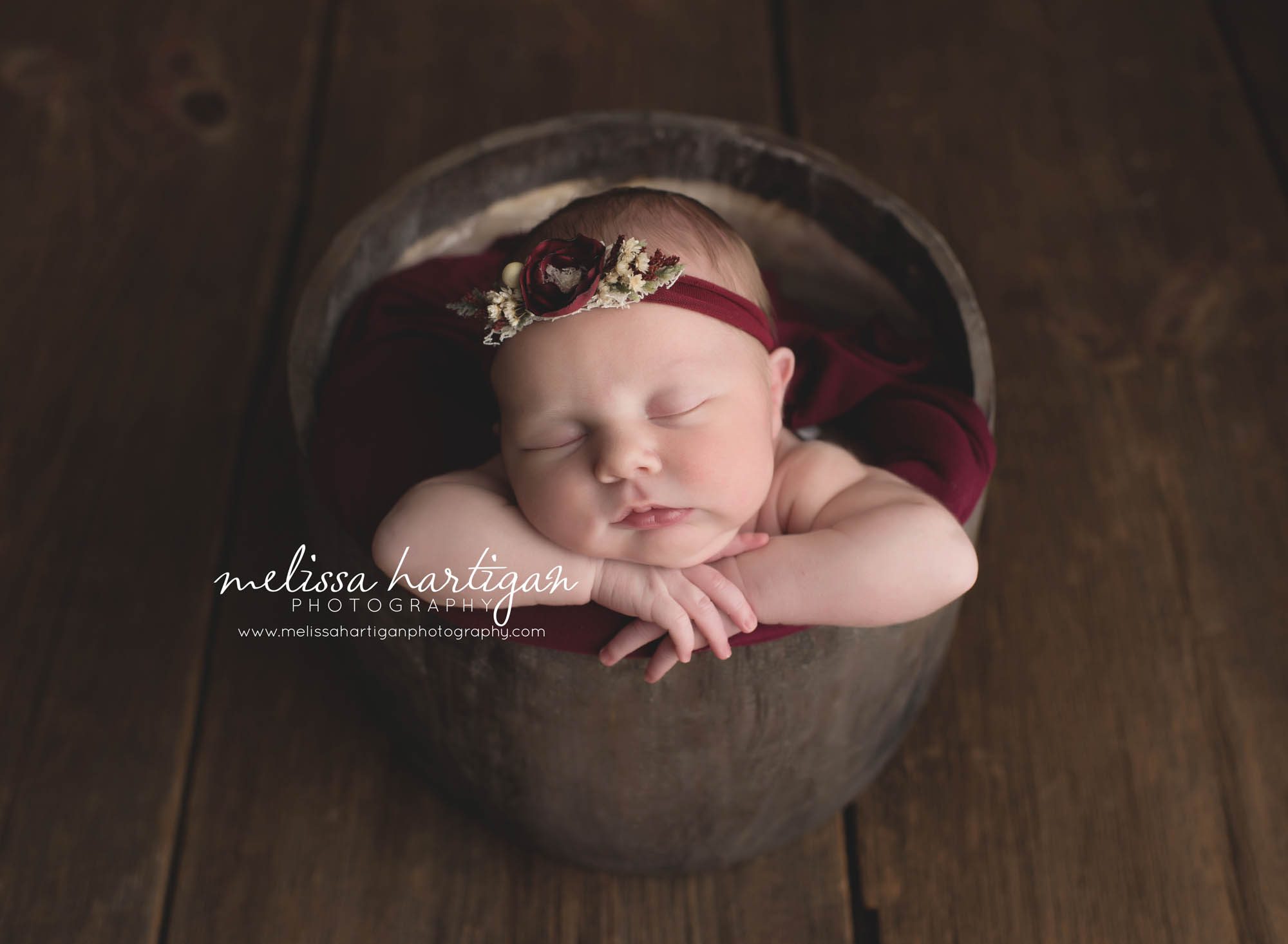 Melissa Hartigan Photography Connecticut Newborn Photographer Coventry Ct Middlefield CT baby Fairfield county Baby girl maroon headband maroon blanket sleeping in wooden bowl head on hands CT newborn session