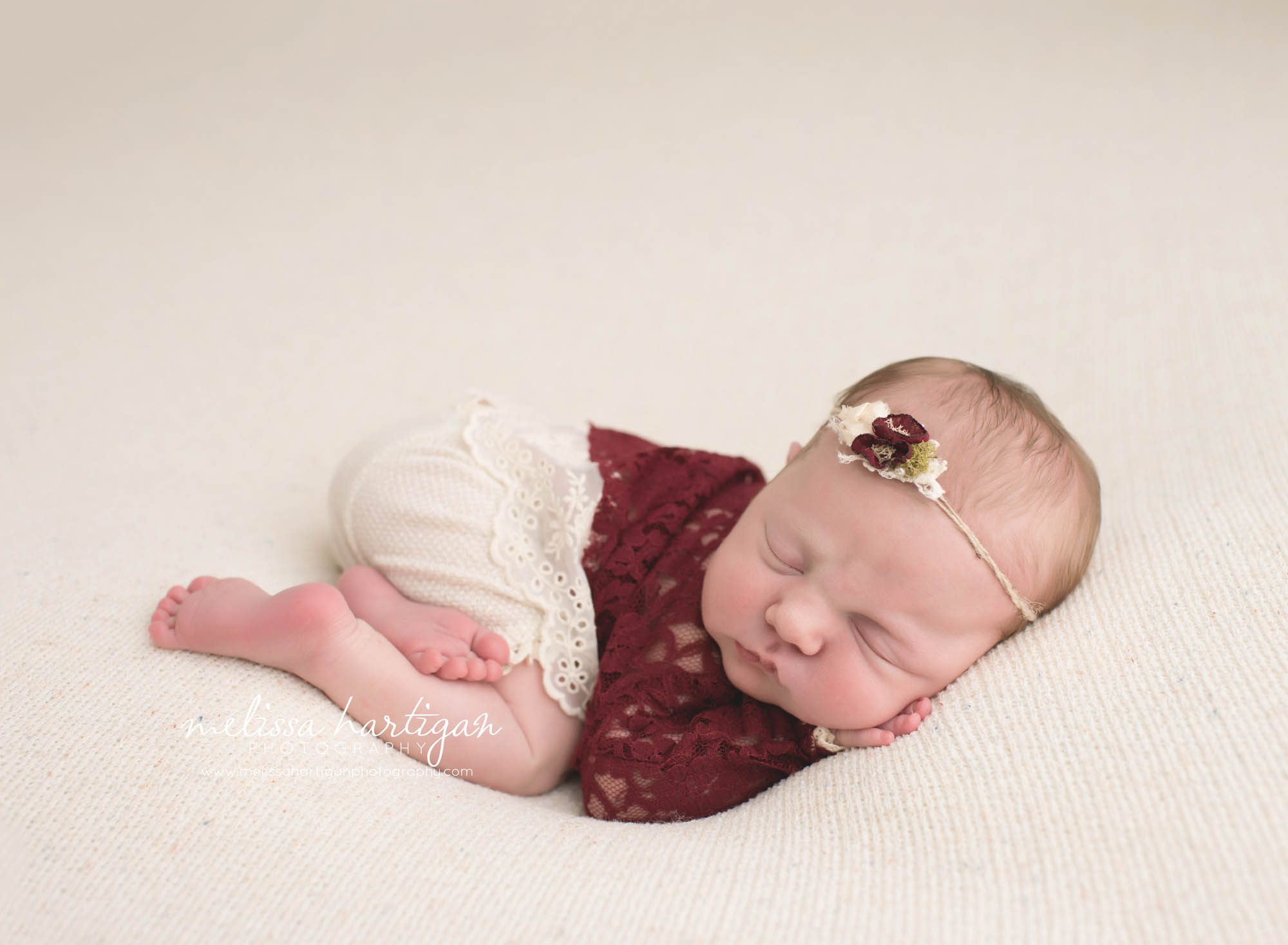 Melissa Hartigan Photography Connecticut Newborn Photographer Coventry Ct Middlefield CT baby Fairfield county Baby girl cream headband with maroon flowers maroon lace top cream lace shorts sleeping head on hands CT newborn session