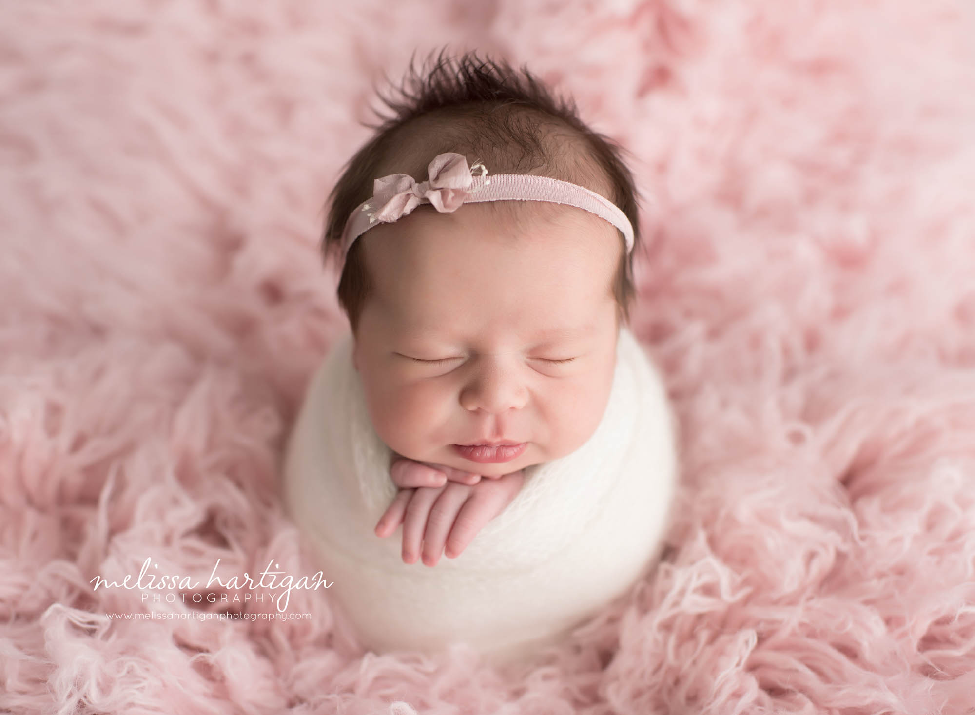 Melissa Hartigan Photography Connecticut Newborn Photographer Coventry Ct Middlefield CT baby Fairfield county Newborn and maternity photography Baby girl pink headband in pink wrap on pink flokati sleeping