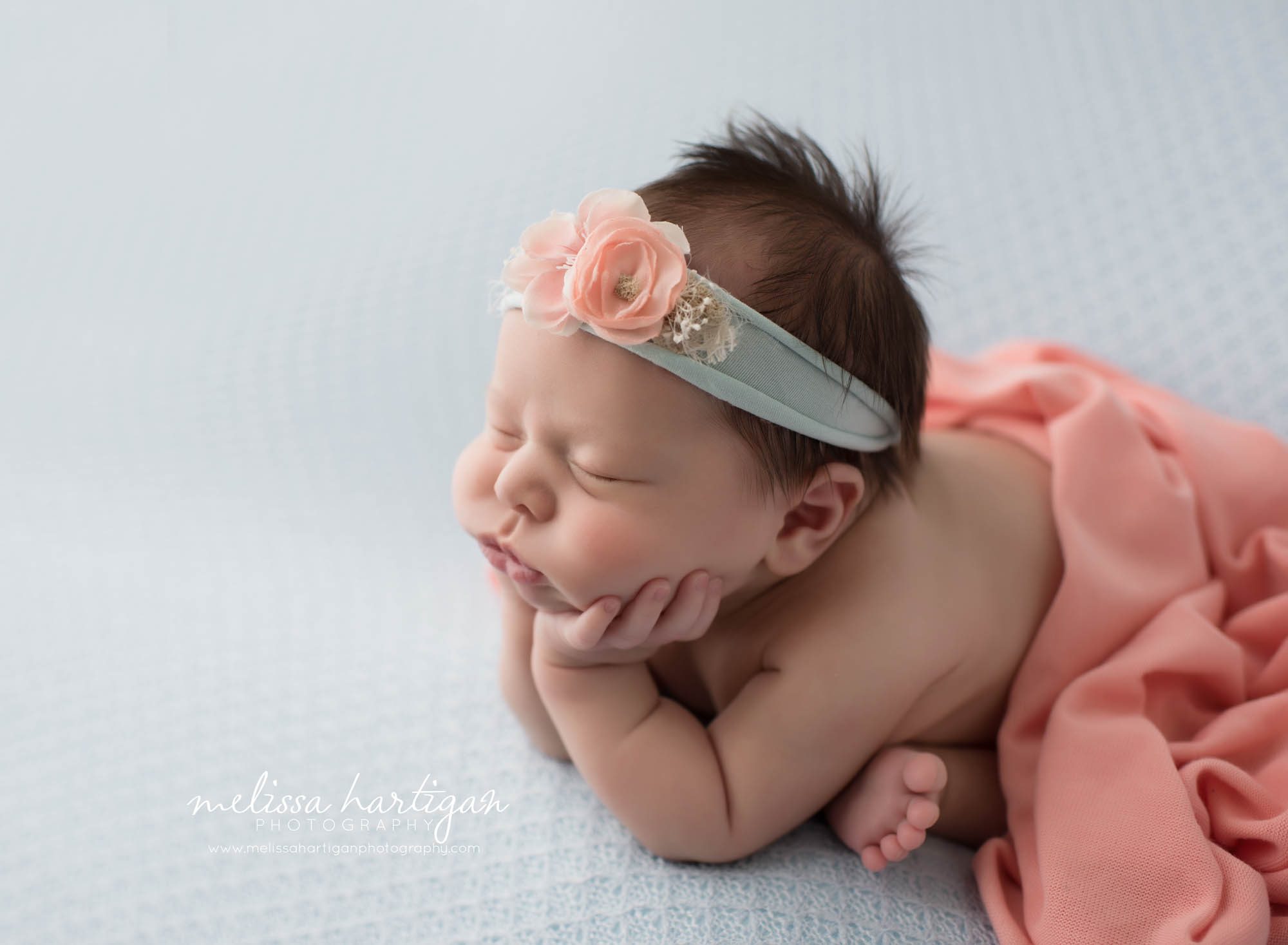 Melissa Hartigan Photography Connecticut Newborn Photographer Coventry Ct Middlefield CT baby Fairfield county Newborn and maternity photography Baby girl blue and coral headband in froggy pose shot from side angle with coral wrap covering tushy sleeping