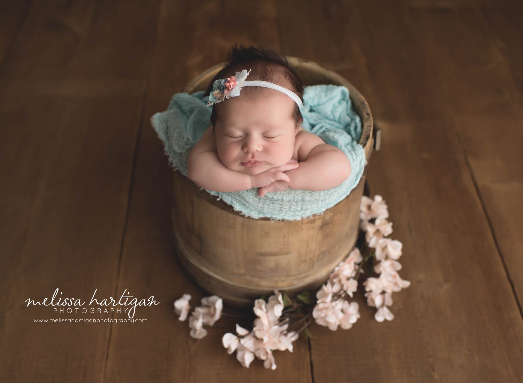 Melissa Hartigan Photography Connecticut Newborn Photographer Coventry Ct Middlefield CT baby Fairfield county Newborn and maternity photography Baby girl floral headband sleeping in wooden bucket with blue wrap