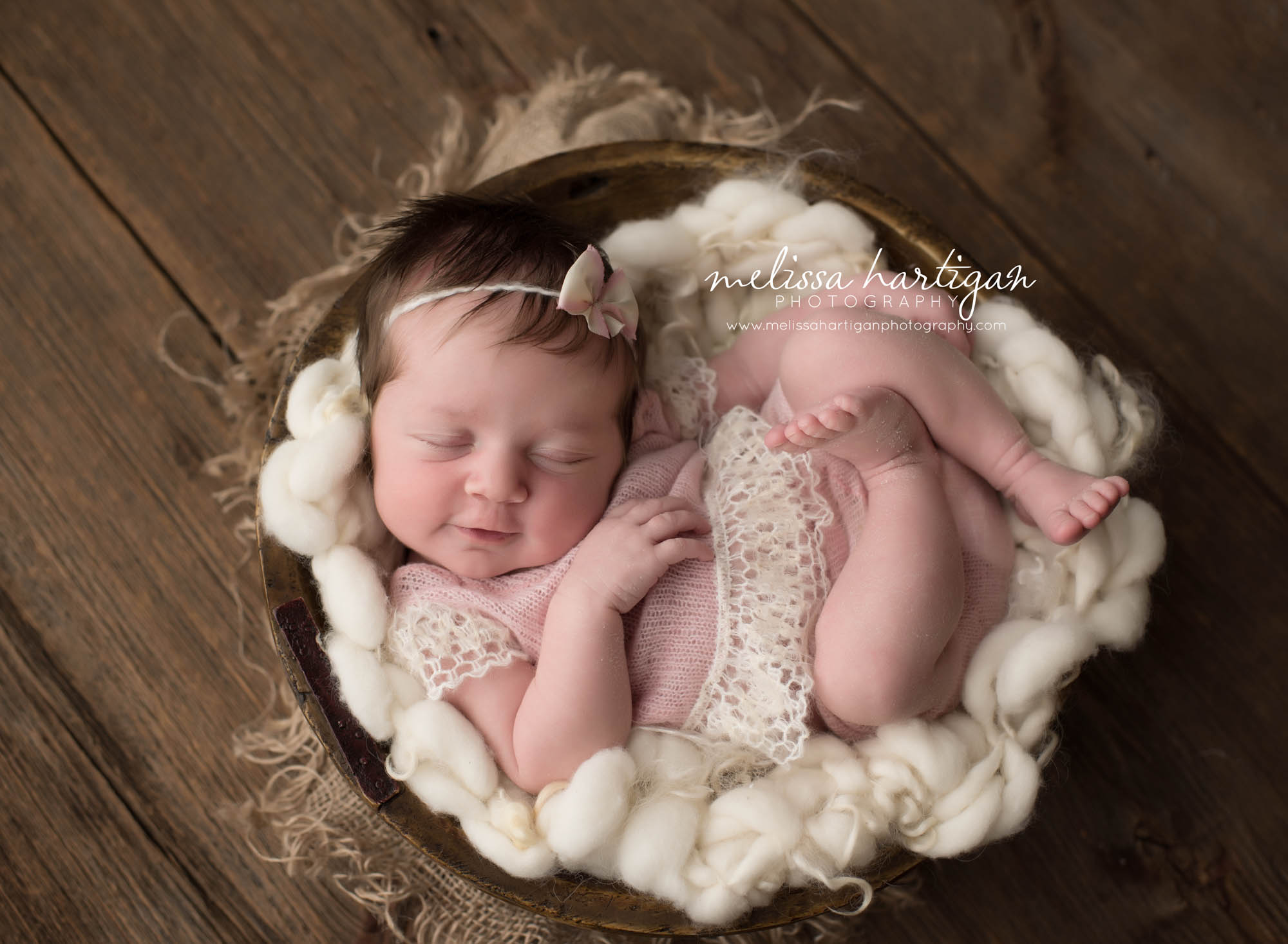 Melissa Hartigan Photography Connecticut Newborn Photographer Coventry Ct Middlefield CT baby Fairfield county Newborn and maternity CT photographer Baby girl in wooden bucket wearing pink knit outfit and headband on top of white chunky knit blanket