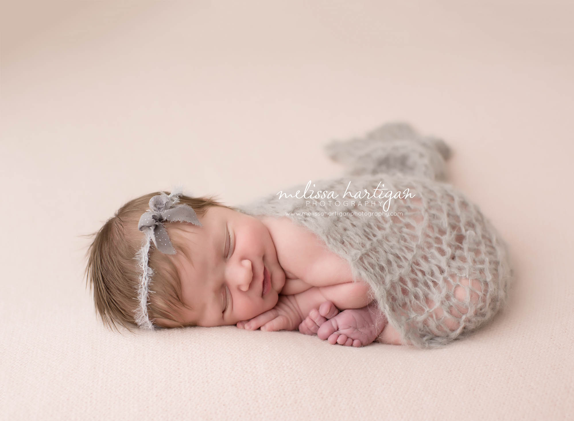 Melissa Hartigan Photography Connecticut Newborn Photographer Coventry Ct Middlefield CT baby Fairfield county Newborn and maternity CT photographer Baby girl gray headband sleeping on pale pink blanket with gray knit wrap