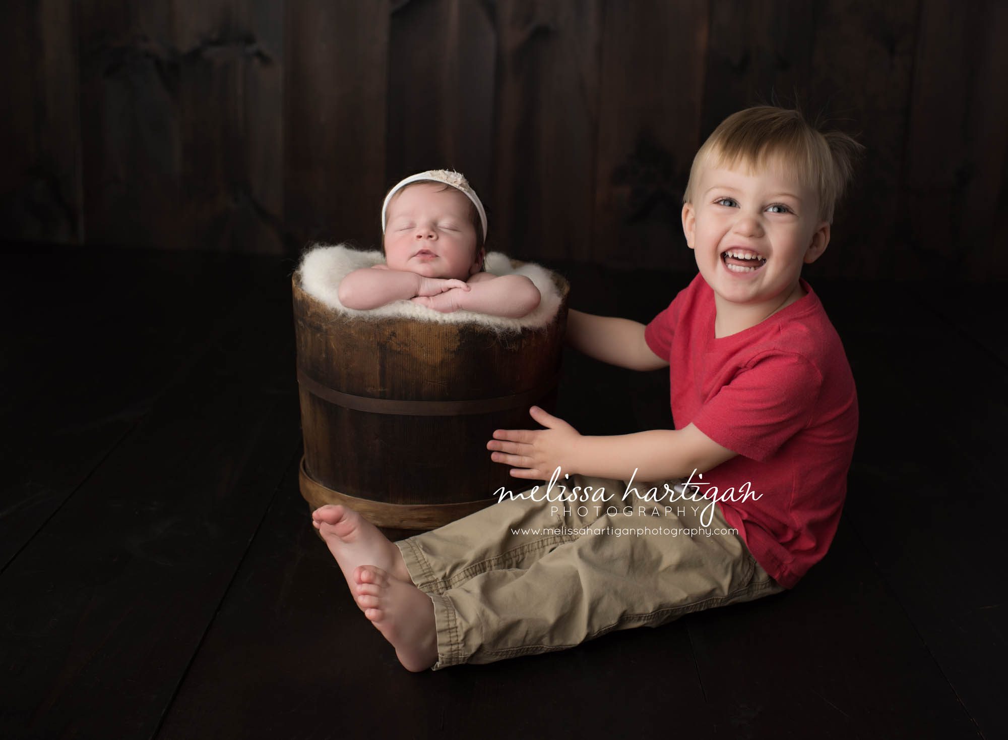 Melissa Hartigan Photography Connecticut Newborn Photographer Coventry Ct Middlefield CT baby Fairfield county Newborn and maternity CT photographer Baby girl white headband in wooden bucket posed with big brother smiling