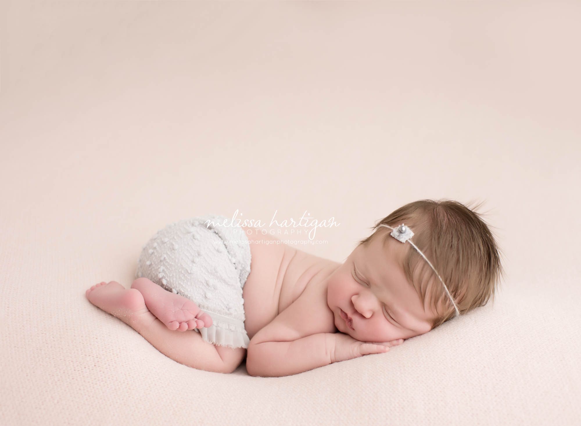 Melissa Hartigan Photography Connecticut Newborn Photographer Coventry Ct Middlefield CT baby Fairfield county Newborn and maternity CT photographer Baby girl gray headband and knit shorts laying on pink blanket