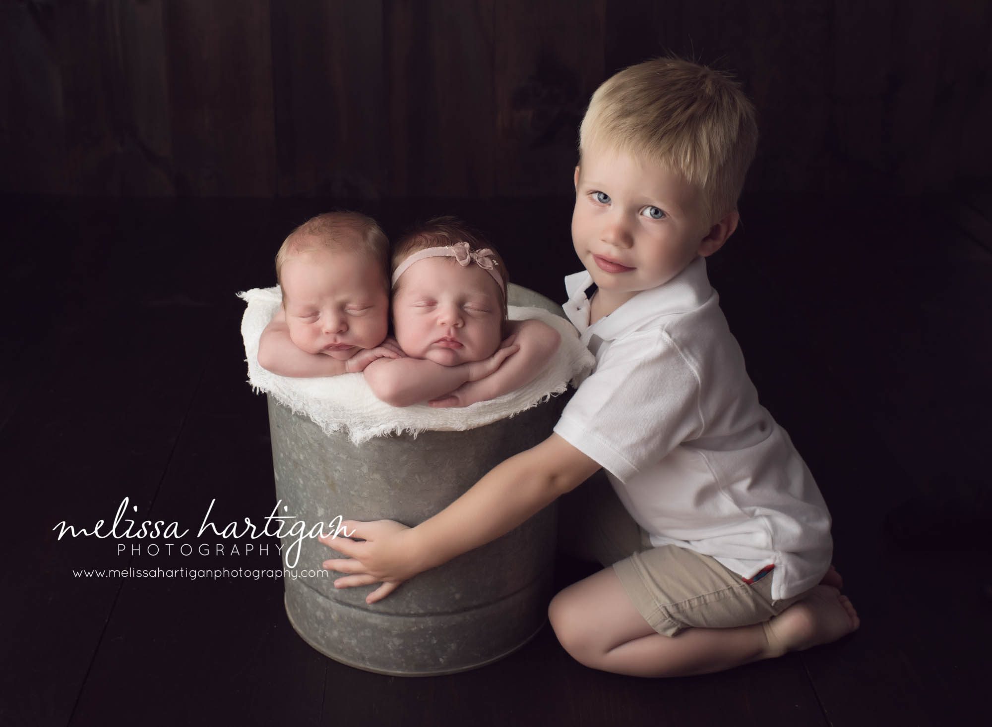Melissa Hartigan Photography Connecticut Newborn twin Photographer Coventry Ct Middlefield CT baby Fairfield county Newborn and maternity CT photographer Newborn twin photographer baby twins sleeping in metal bucket with big brother holding bucket