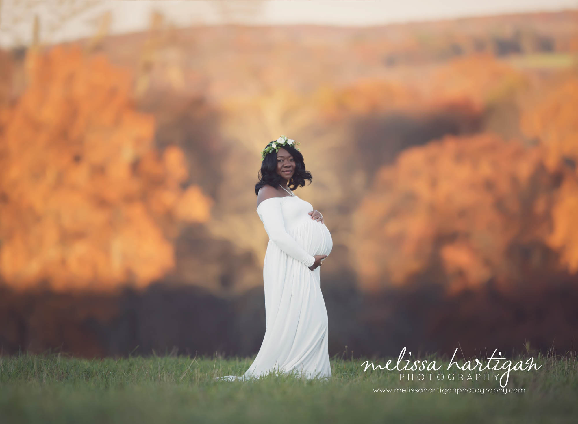 Melissa Hartigan Photography Connecticut Maternity and Newborn CT Photographer Coventry Ct Middlefield CT baby Fairfield county Maternity pose mommy-to-be wearing white maternity dress and floral wreath holding belly standing in field