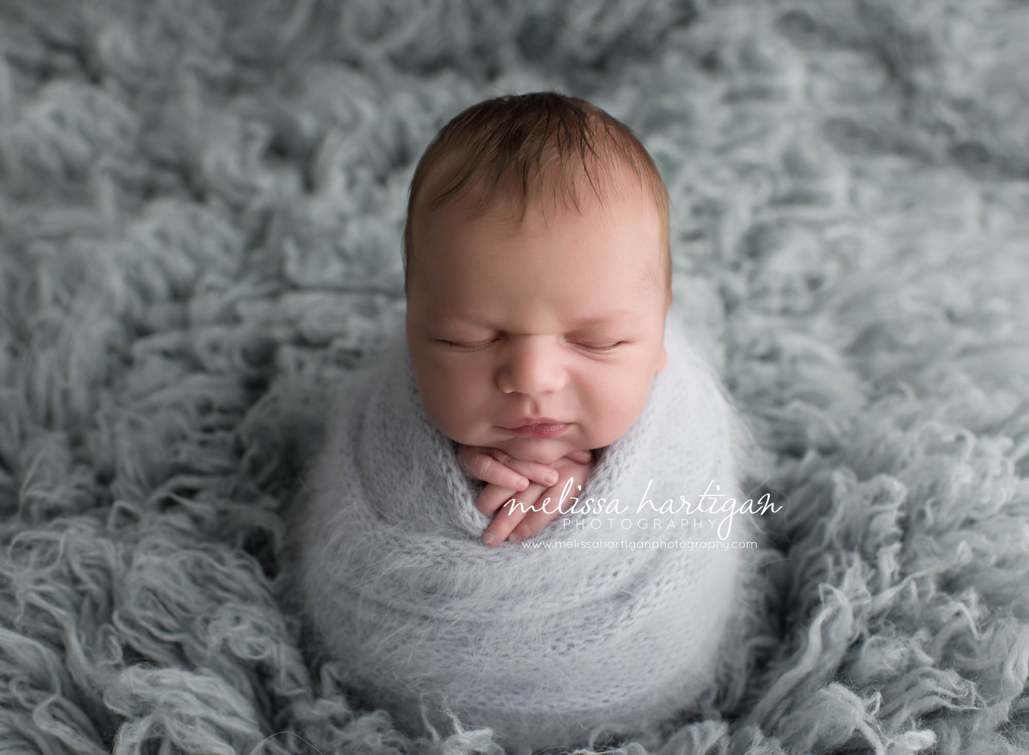 Melissa Hartigan Photography Coventry CT Simply Swaddled Newborn Session baby boy wrapped in pale blue knit on blue flokati