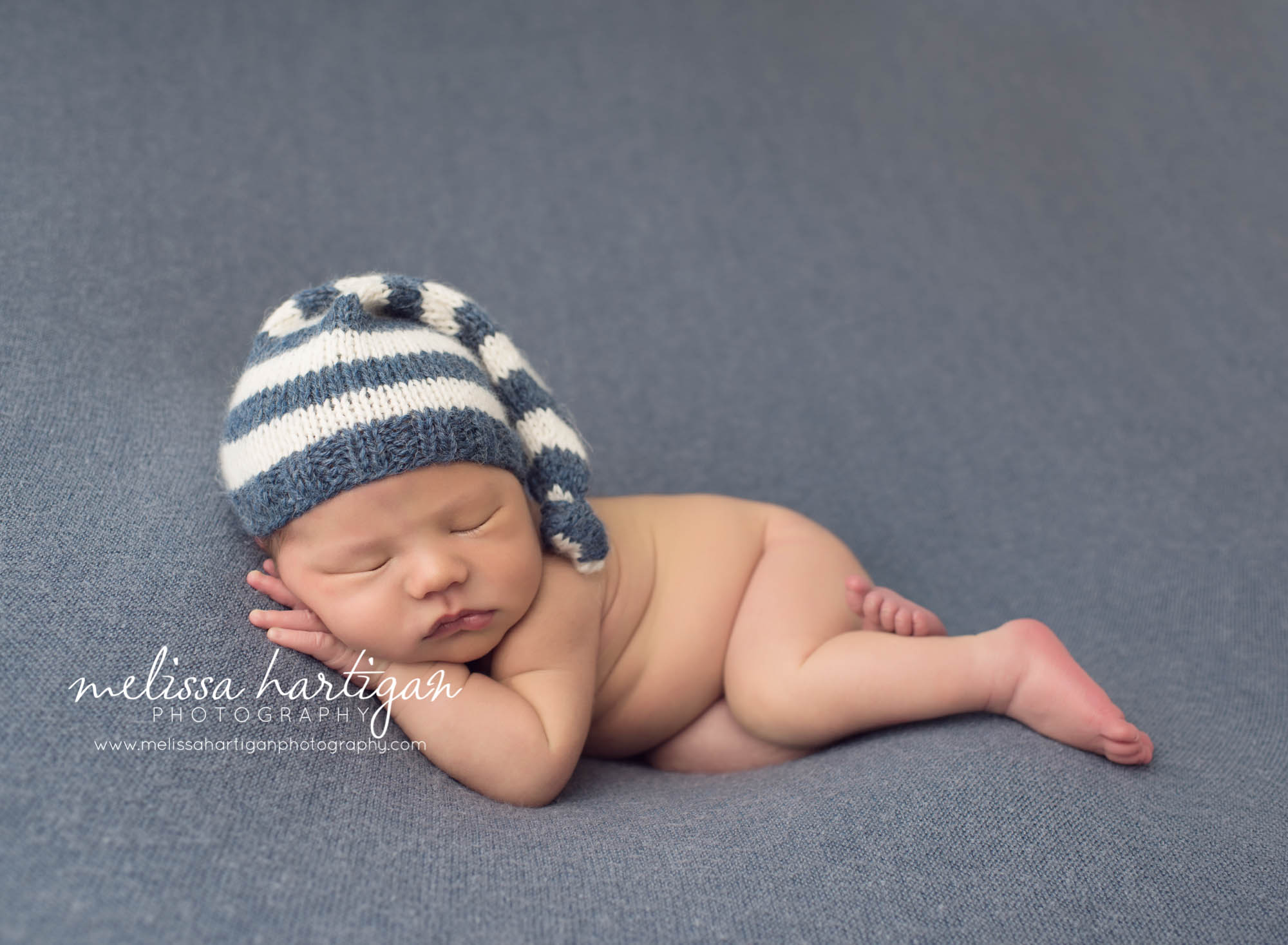 Melissa Hartigan Photography Maternity and Newborn Connecticut Photographer Lucas Newborn Session Baby boy sleeping on blue blanket with blue and cream striped knit hat