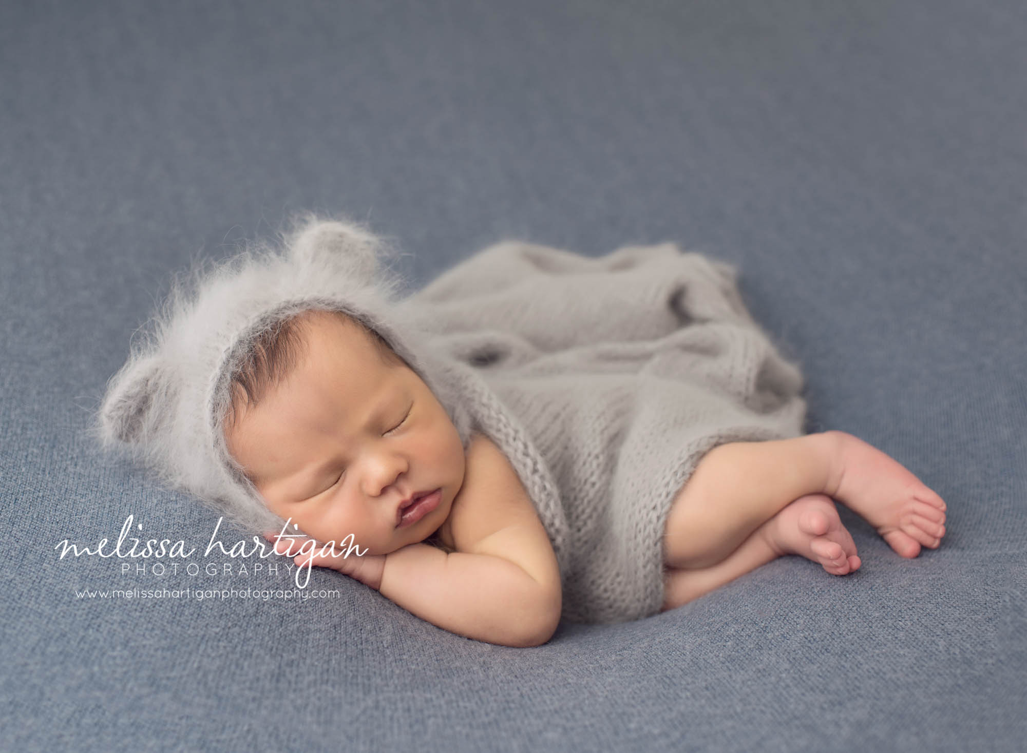 Melissa Hartigan Photography Maternity and Newborn Connecticut Photographer Lucas Newborn Session Baby boy laying on blue blanket with light blue knit blanket over him wearing blue knit hat with ears