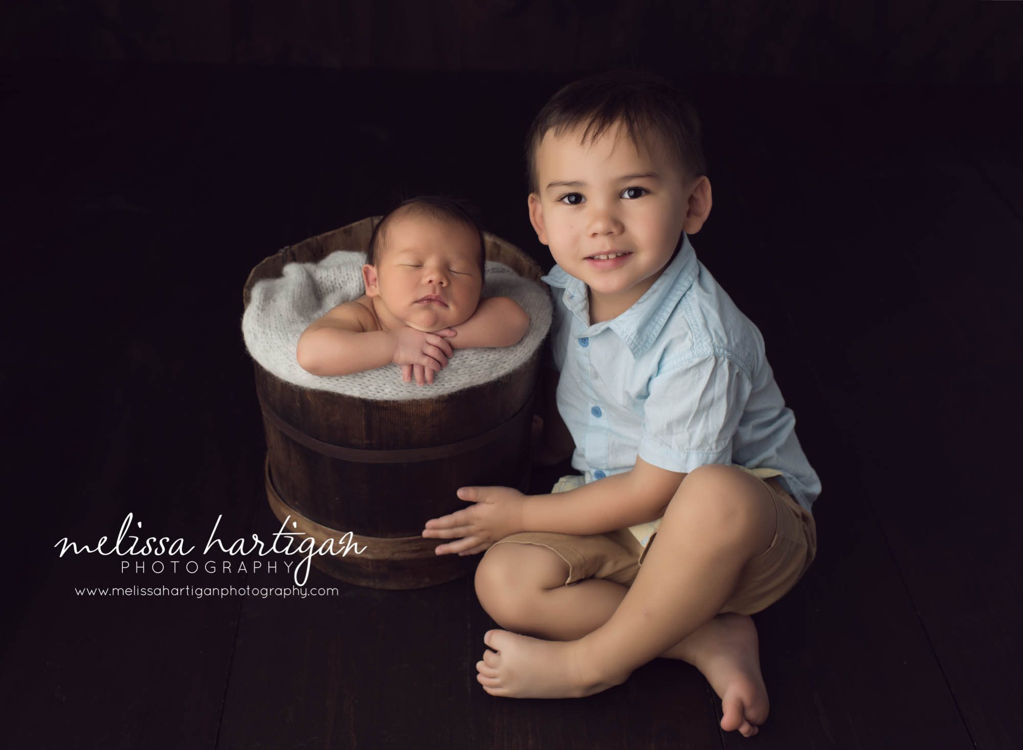 Melissa Hartigan Photography Maternity and Newborn Connecticut Photographer Lucas Newborn Session Baby boy sleeping in wooden bucket with light blue knit blanket posed with big brother