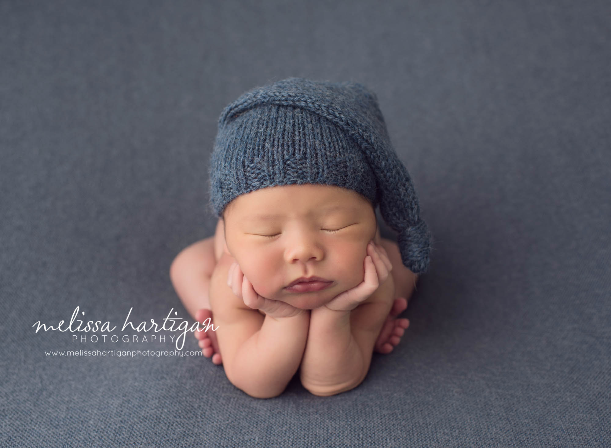 Melissa Hartigan Photography Maternity and Newborn Connecticut Photographer Lucas Newborn Session Baby boy in froggy pose wearing blue knit hat on blue blanket