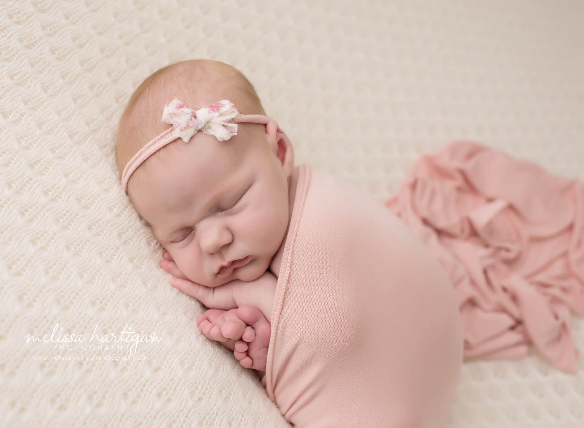 Melissa Hartigan Photography Connecticut Newborn Photographer in Coventry baby girl sleeping wrapped in pink with pink bow headband
