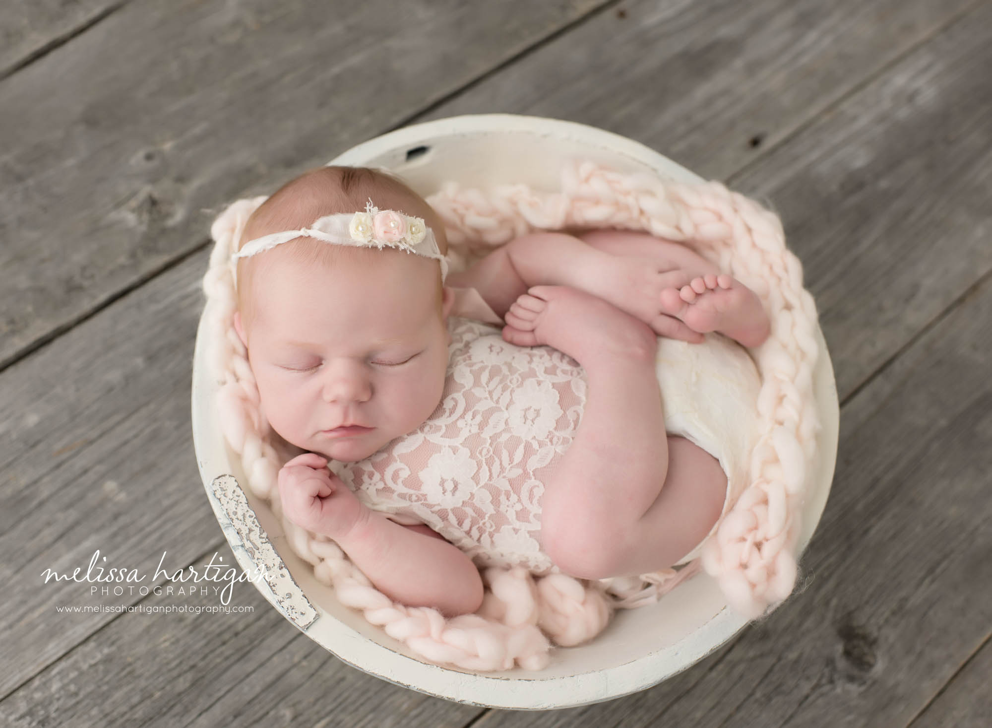 Melissa Hartigan Photography Connecticut Newborn Photographer in Coventry baby girl sleeping in white wooden bowl wearing lace romper and floral headband