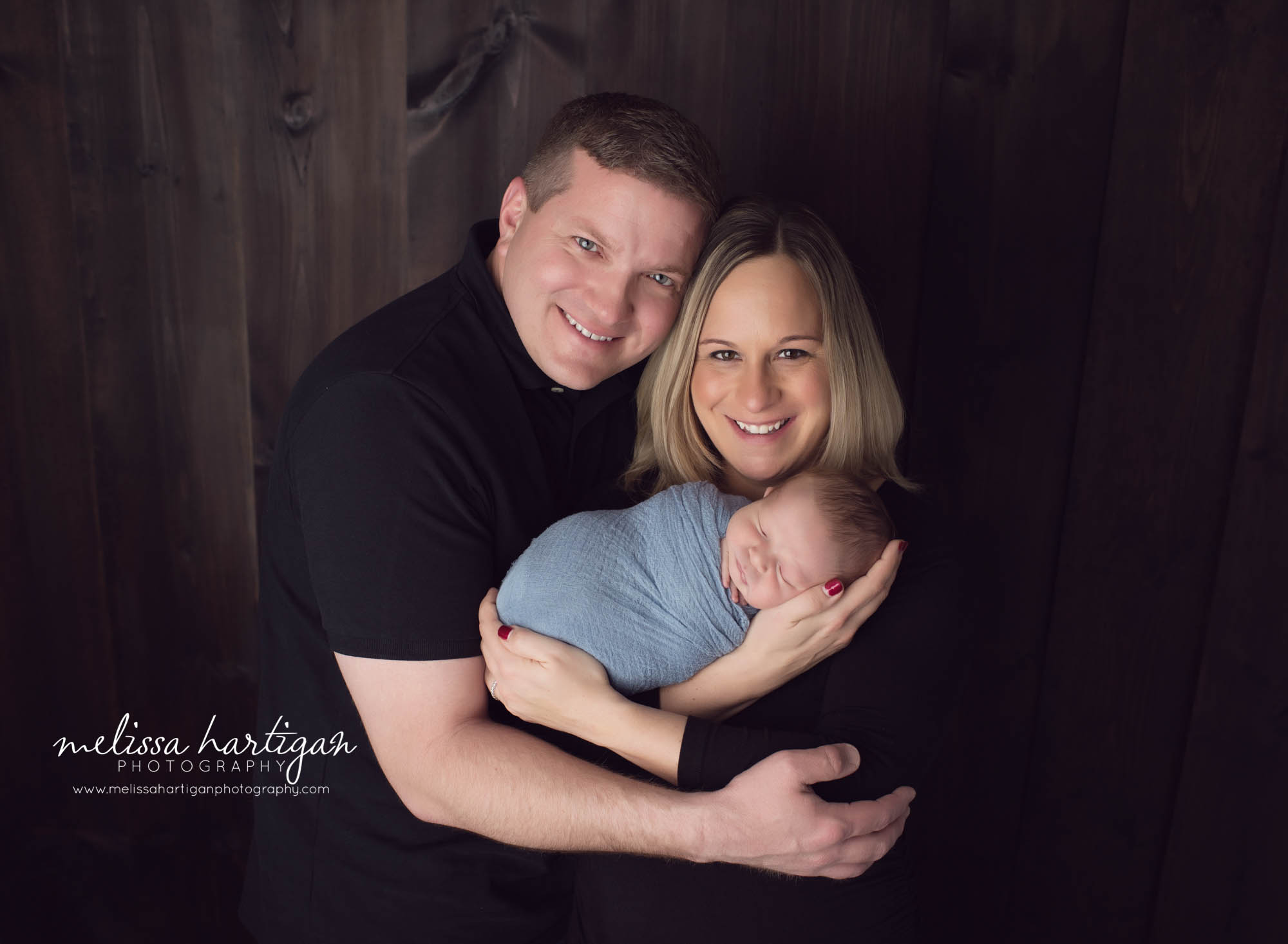 Melissa Hartigan Photography Newborn Photographer Connecticut baby boy wrapped in blue sleeping held by parents