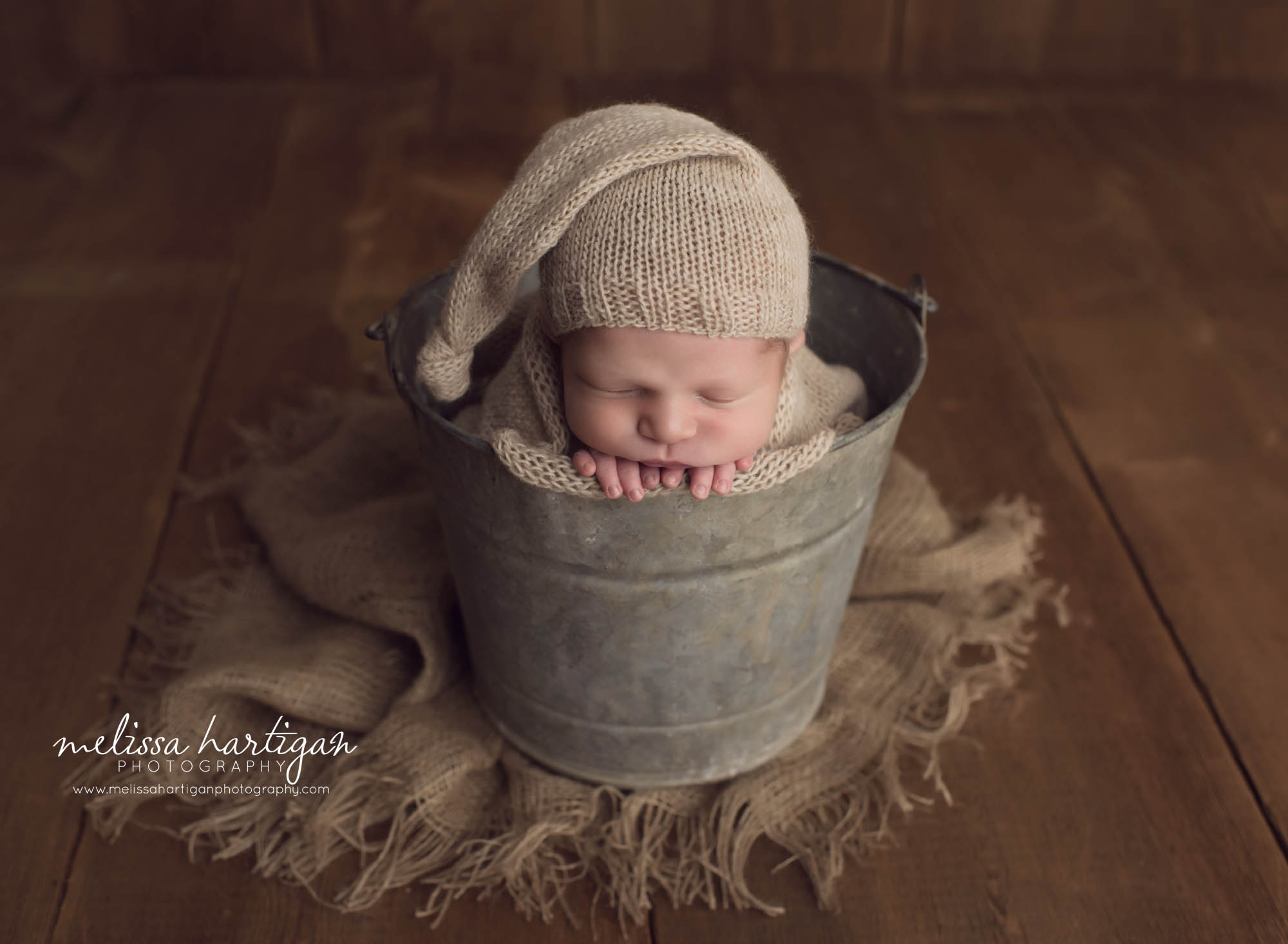 Melissa Hartigan Photography Newborn Photographer Connecticut baby boy wearing knit hat sleeping in metal bucket
