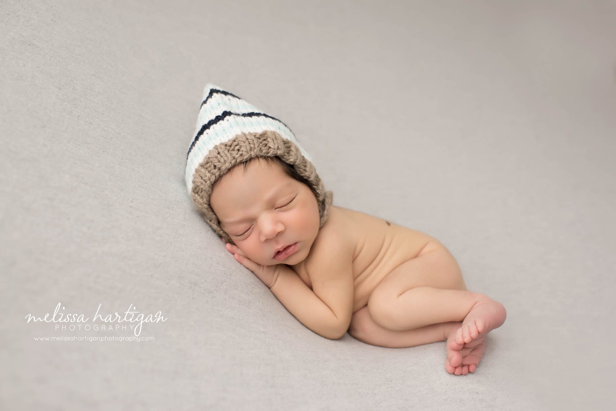 Melissa Hartigan Photography CT Newborn Photographer East Hartford baby boy sleeping on blue blanket wearing striped knit hat
