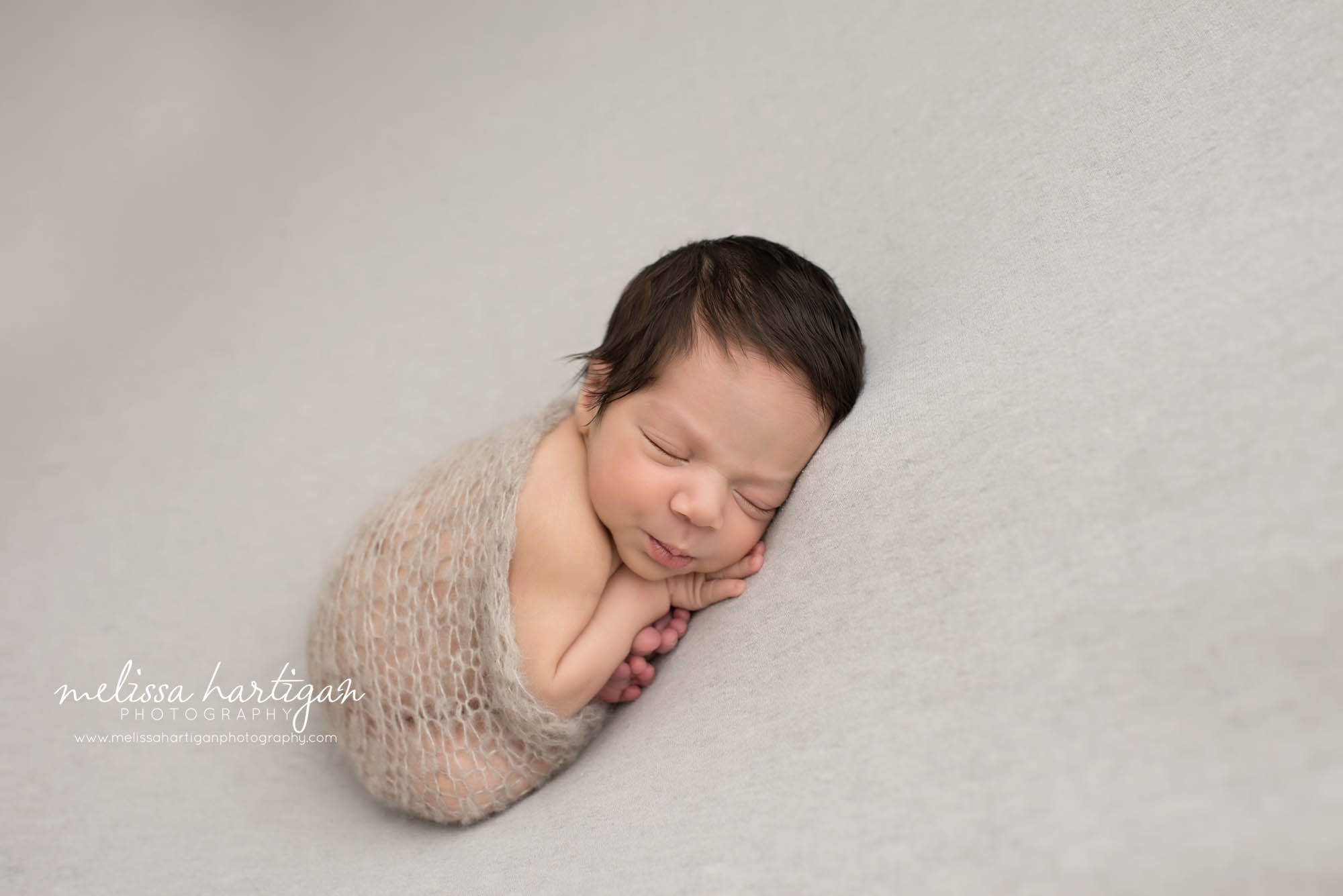 Melissa Hartigan Photography CT Newborn Photographer East Hartford baby boy sleeping on blue blanket wrapped in gray knit blanket 