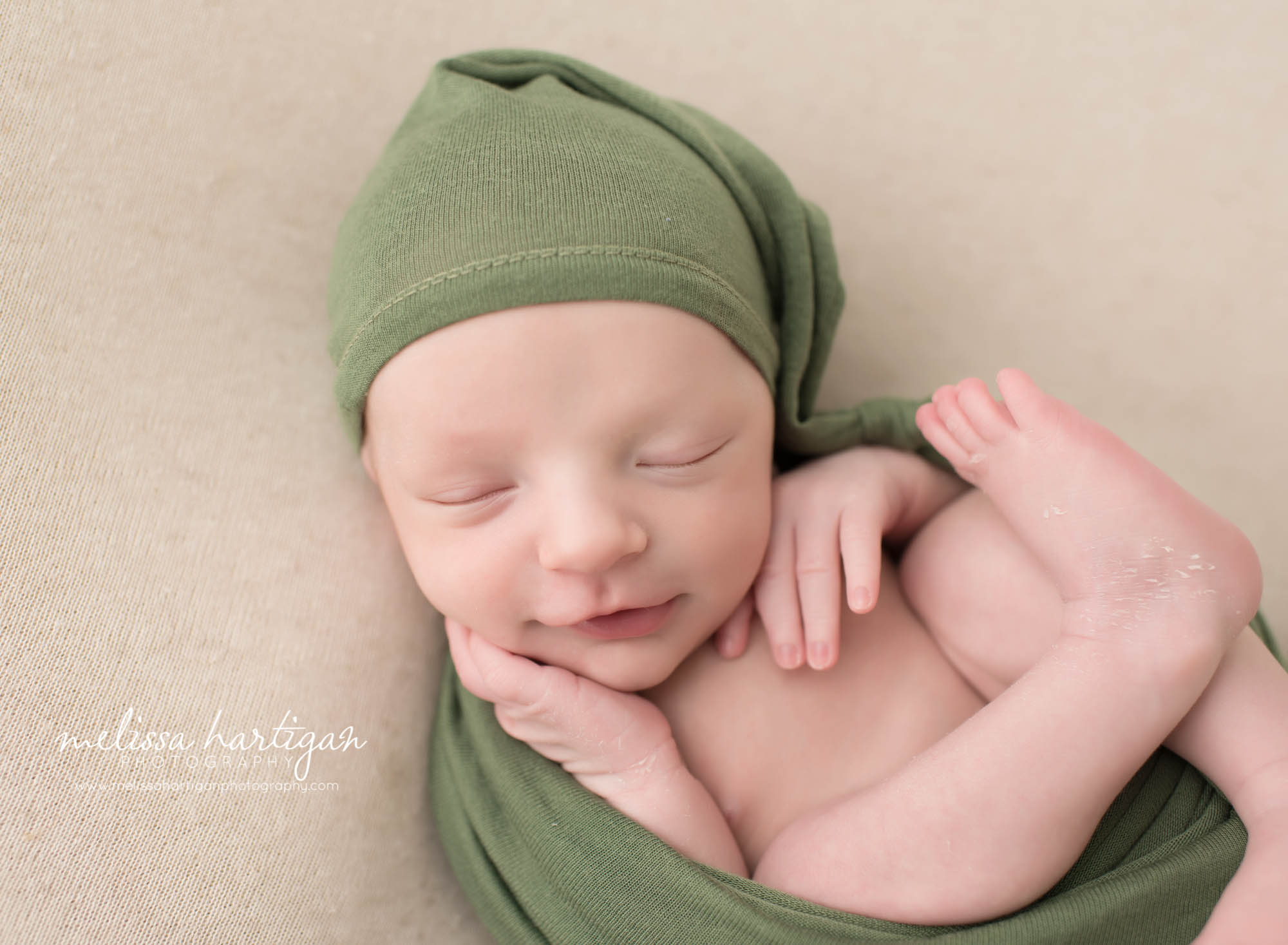 Melissa Hartigan Photography CT Newborn Photographer Stafford baby boy sleeping wearing green hat and wrap smiling