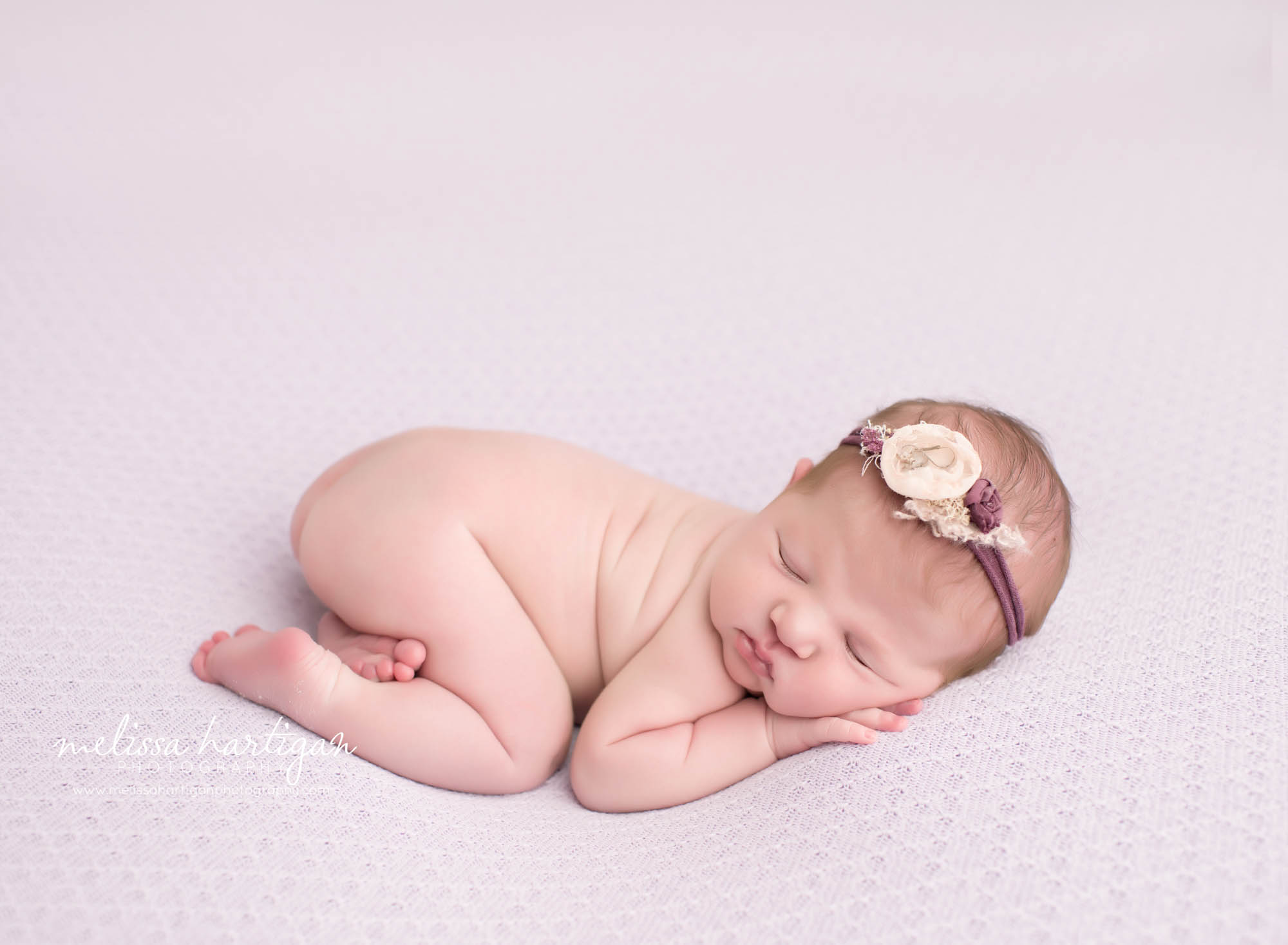 Melissa Hartigan Photography CT Newborn Photographer Ashford baby girl sleeping wearing floral headband on light purple blanket