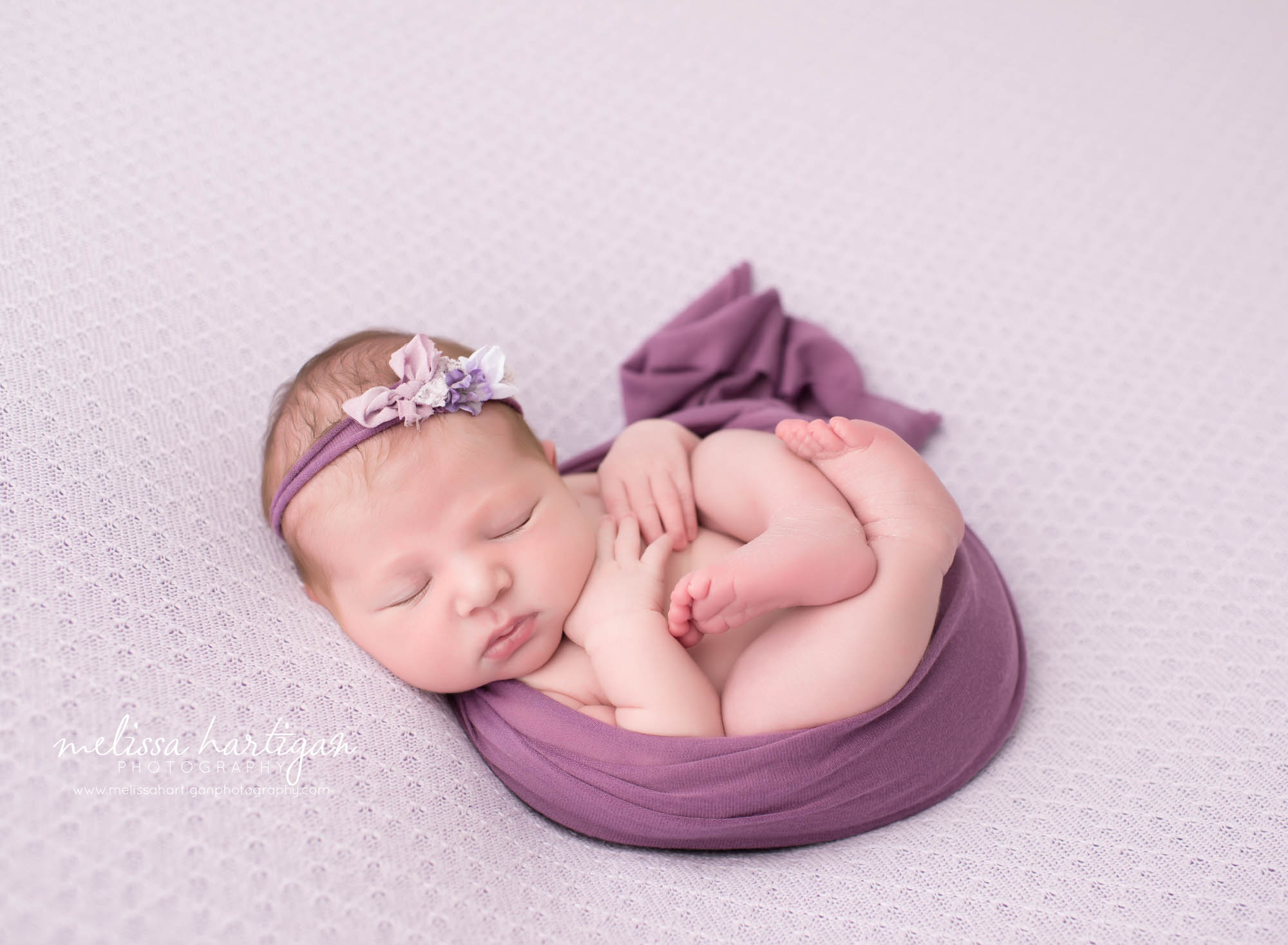 Melissa Hartigan Photography CT Newborn Photographer Ashford baby girl sleeping wrapped in purple with floral headband
