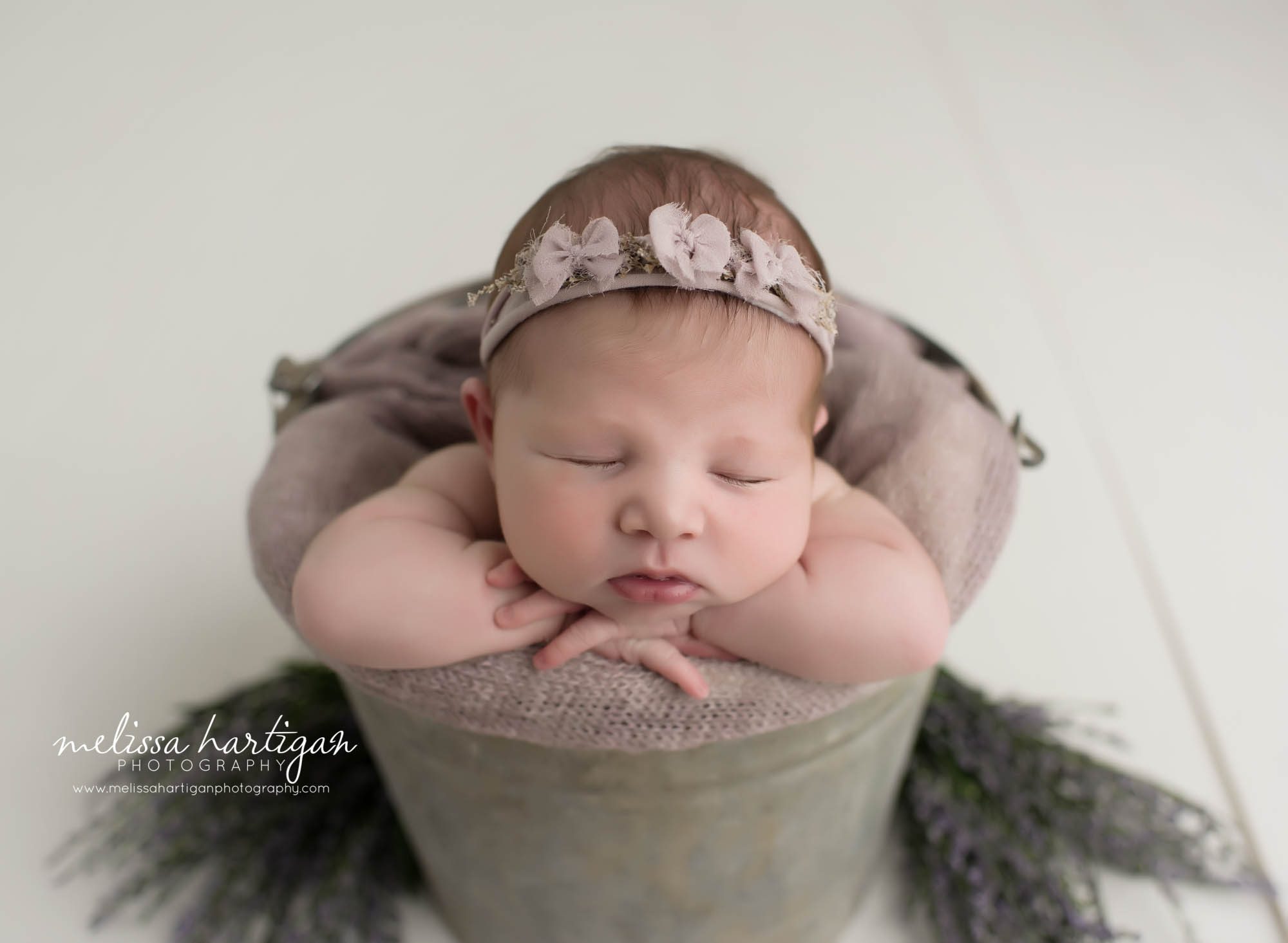 Melissa Hartigan Photography CT Newborn Photographer Ashford baby girl sleeping in metal bucket with light purple blanket wearing purple bow headband