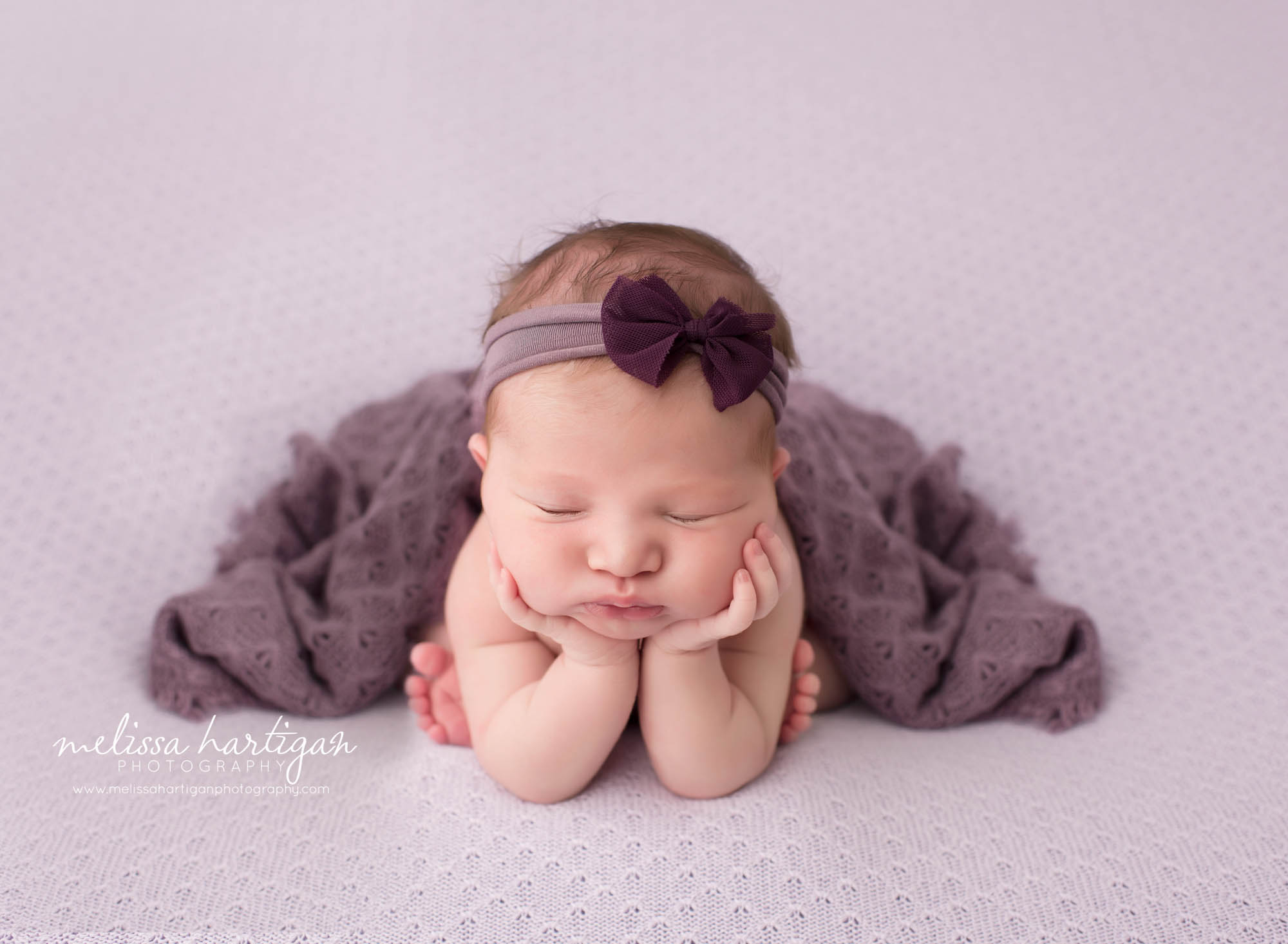Melissa Hartigan Photography CT Newborn Photographer Ashford baby girl sleeping in froggy pose wearing purple bow headband and purple blanket