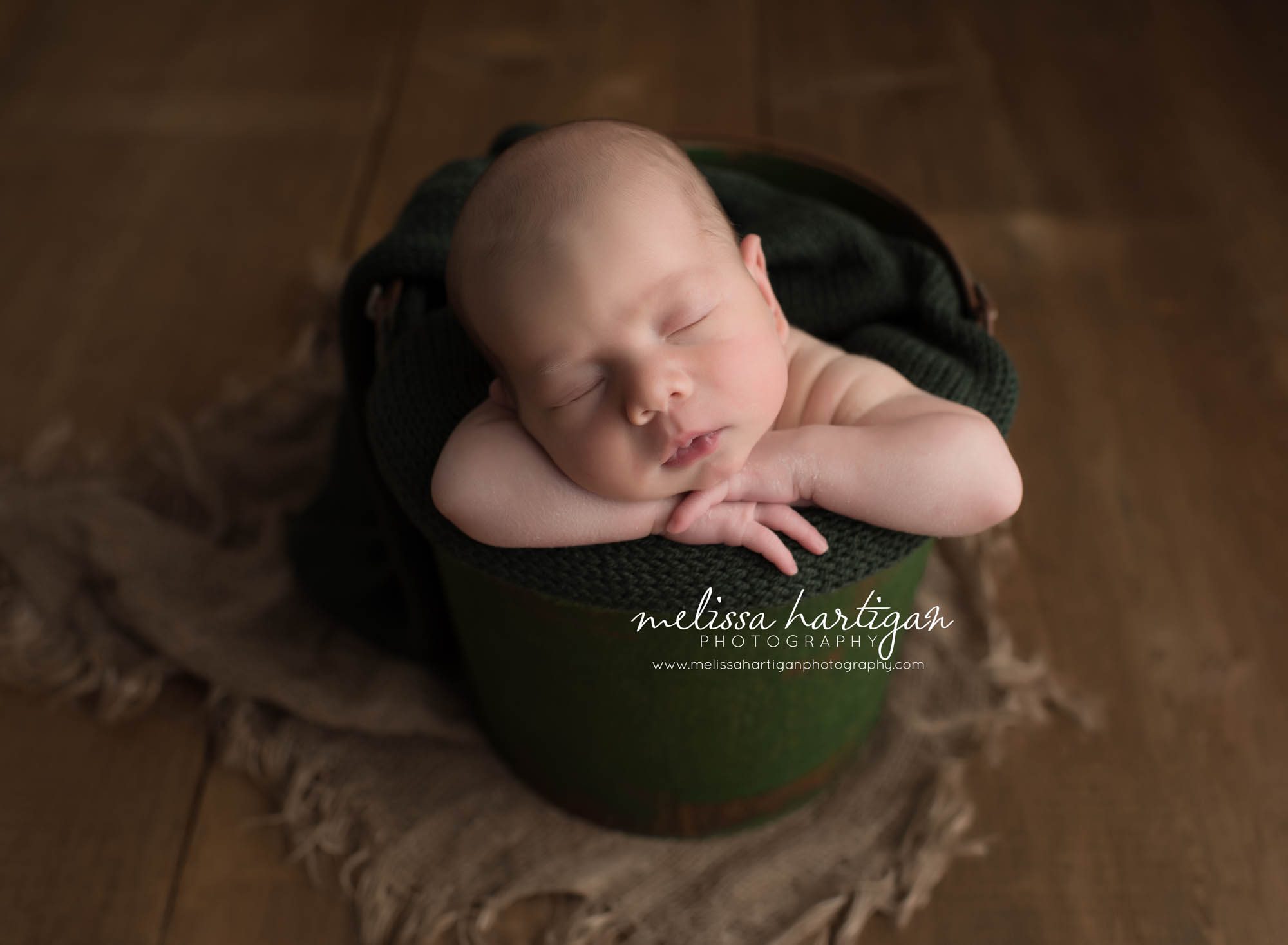 Melissa Hartigan Photography CT Newborn Photographer Taave CT Newborn Session baby boy sleeping in green bucket with green blanket