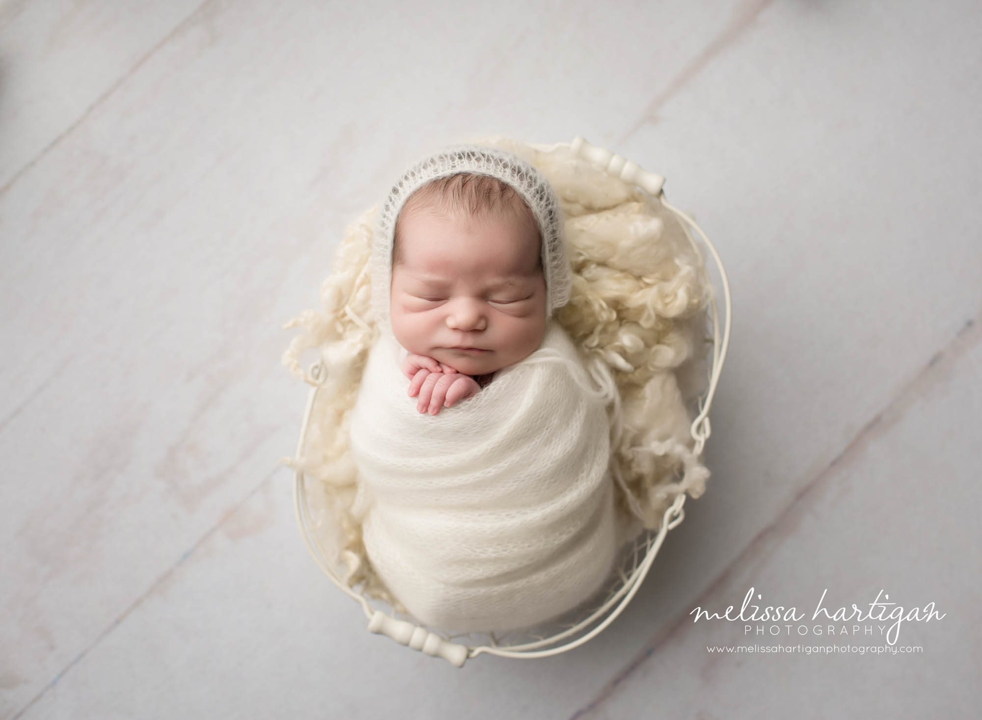 Melissa Hartigan Photography CT Newborn Photographer Emerson CT Newborn Session baby girl sleeping wrapped cream wrap wearing cream knit hat in white wired basket