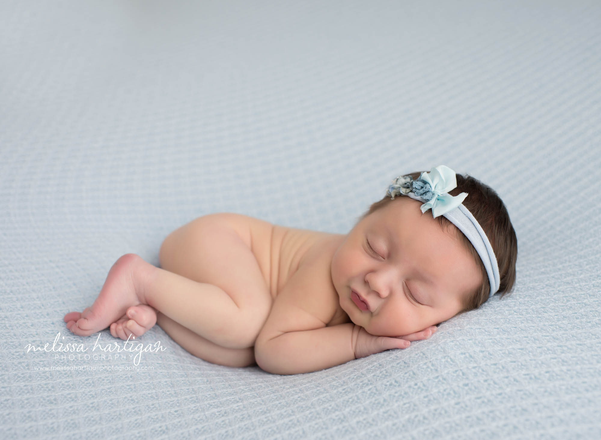 Leila CT Newborn Session baby girl sleeping on blue blanket with floral headband