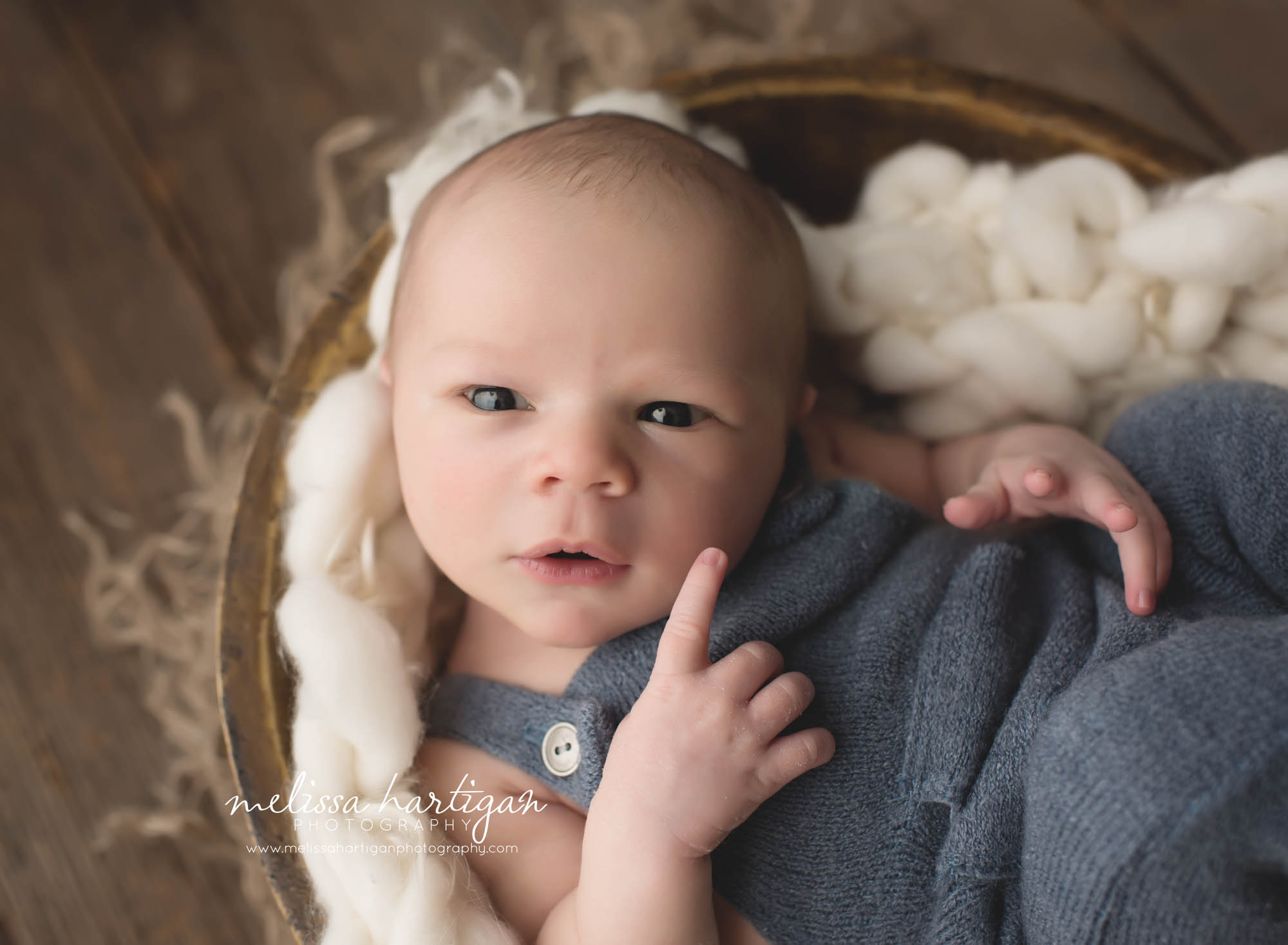 Newborn Session CT baby boy in wooden bowl wearing blue knit overalls