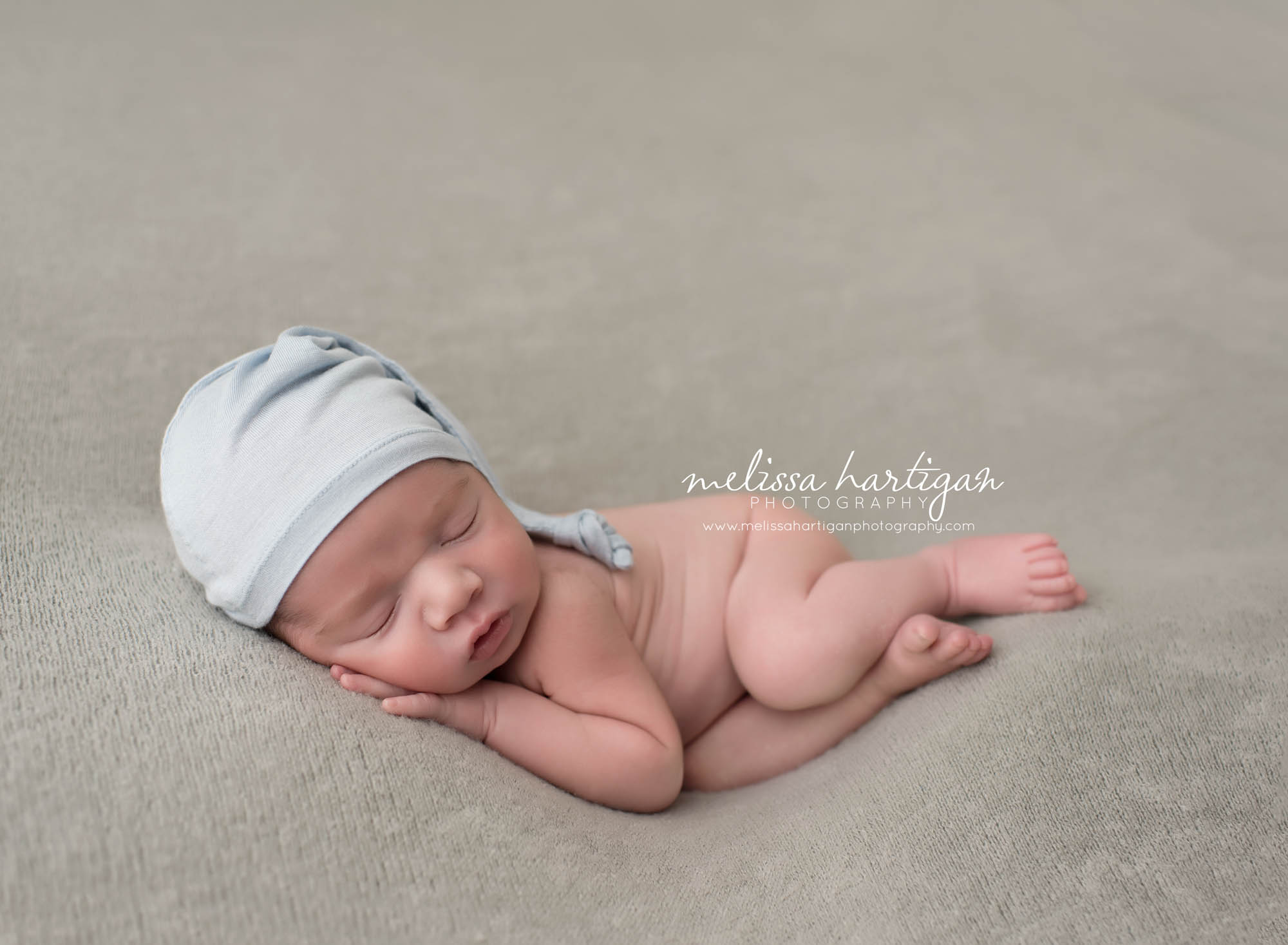 CT Newborn Photographer baby boy sleeping on gray blanket with cap