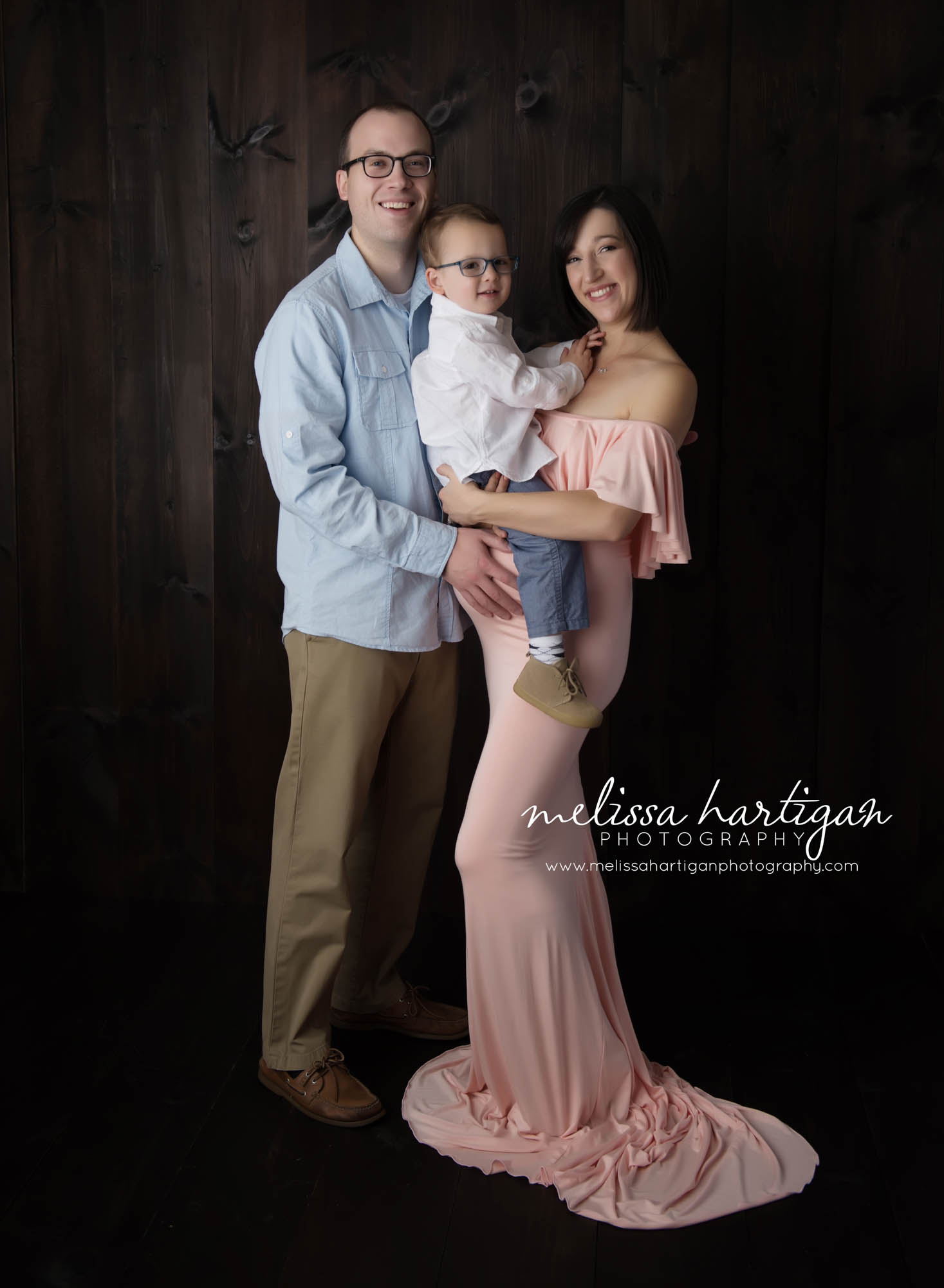 CT Maternity Photographer maternity pose mom wears a long pink strapless gown with family
