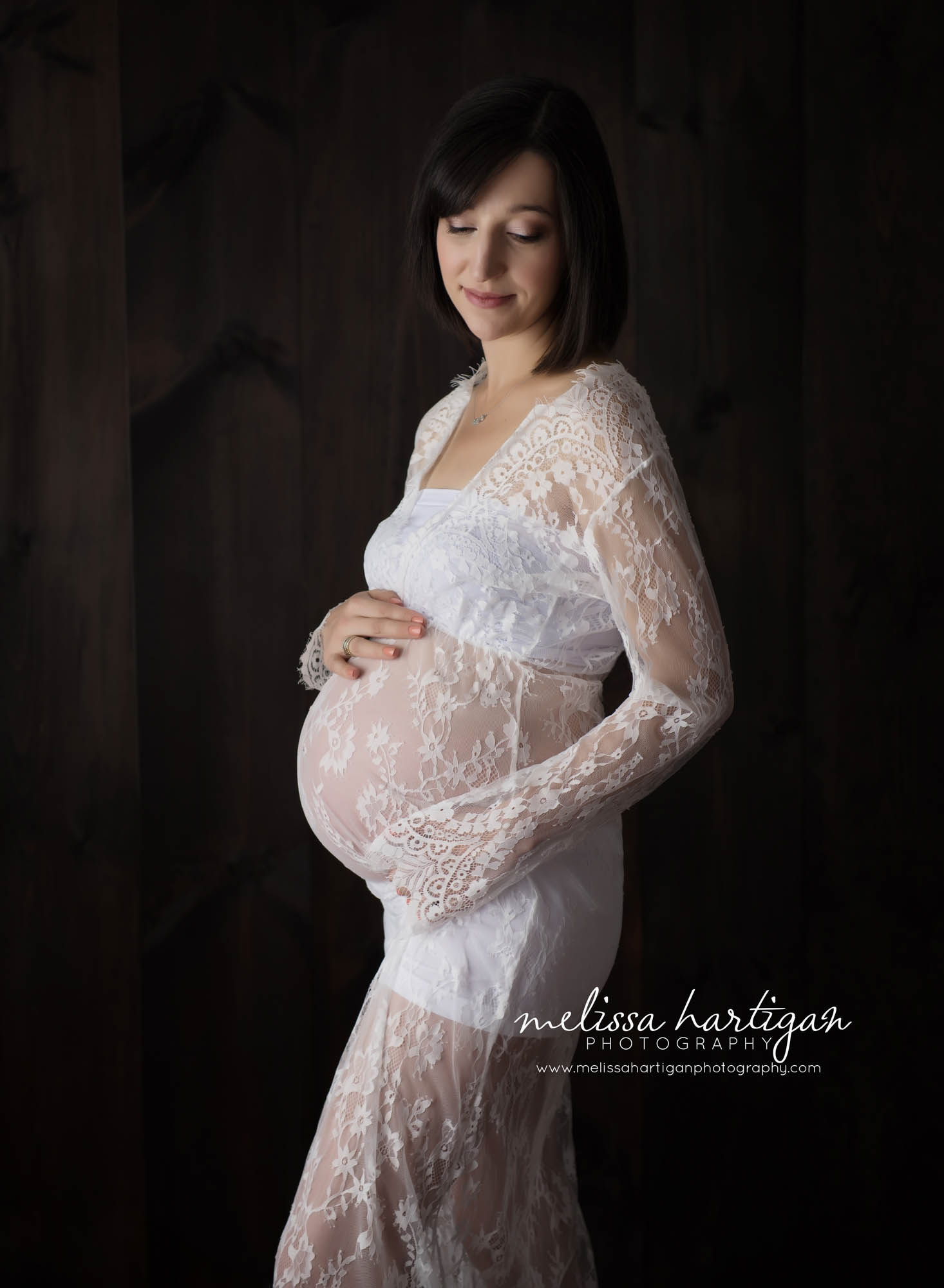 CT Maternity Photographer maternity pose mom cradling baby bump in white lace dress
