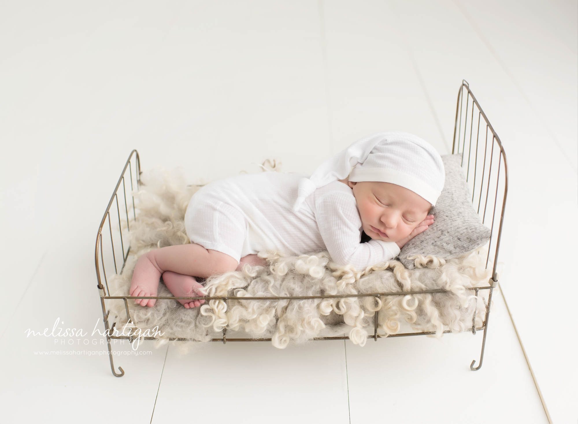 Newborn Photographer Connecticut newborn pose baby sleeping in little metal bed