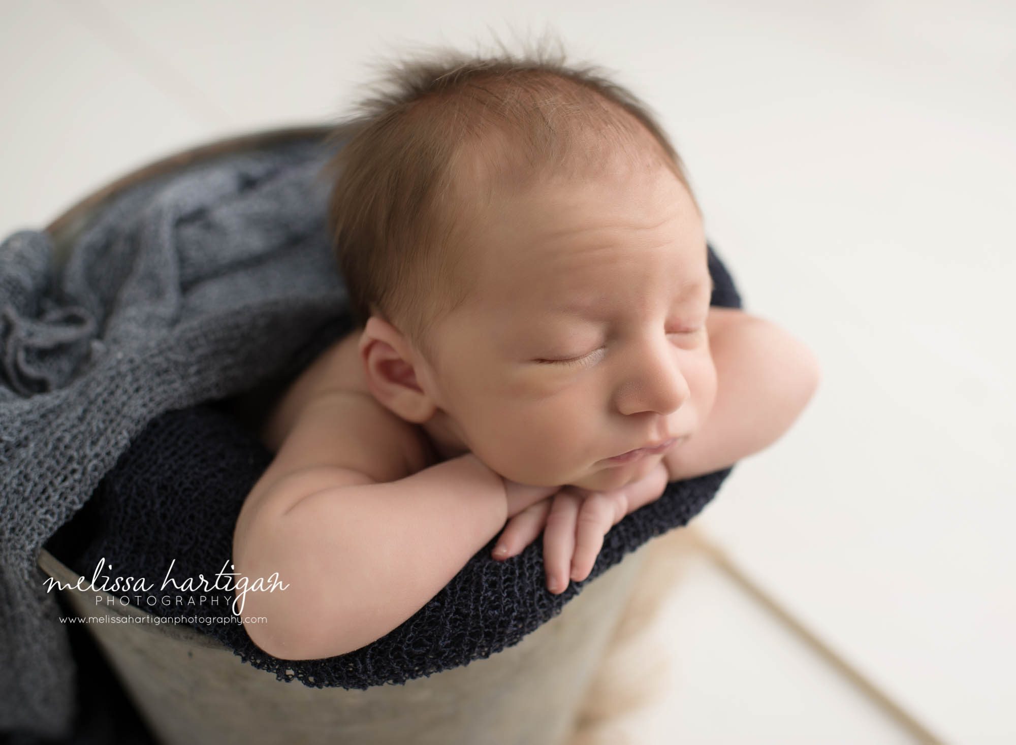 Newborn Photographer Connecticut newborn pose baby sleeping in metal bucket with blue blanket