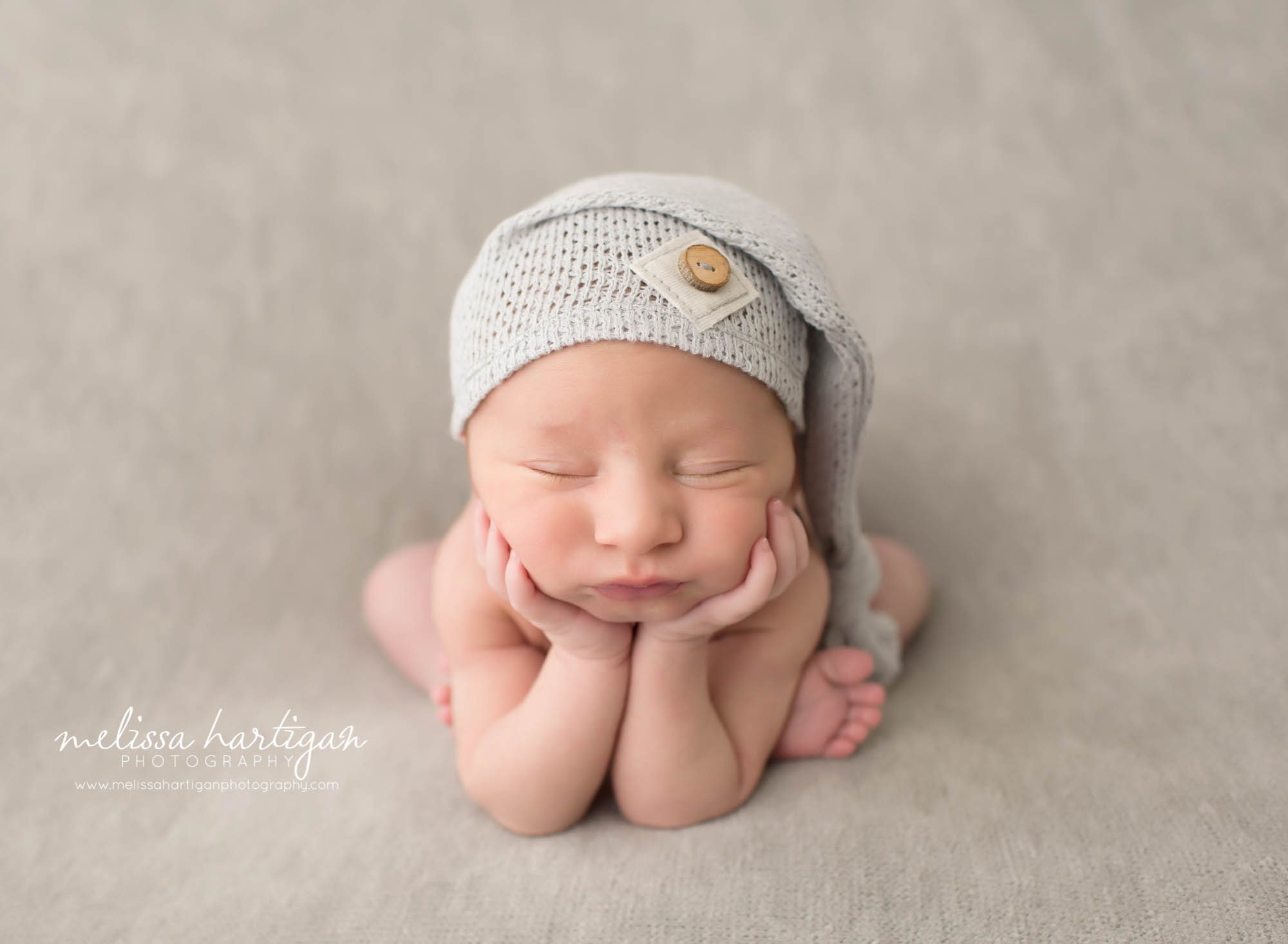 Newborn Photographer Connecticut newborn pose froggy pose wearing knit cap