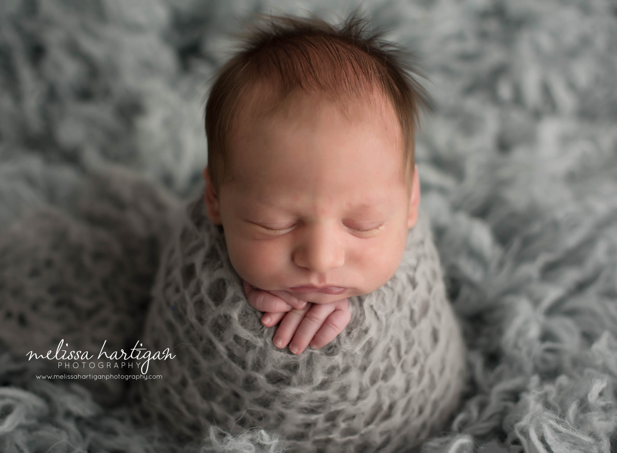 Newborn Photographer Connecticut newborn pose baby sleeping wrapped in gray knit wrap