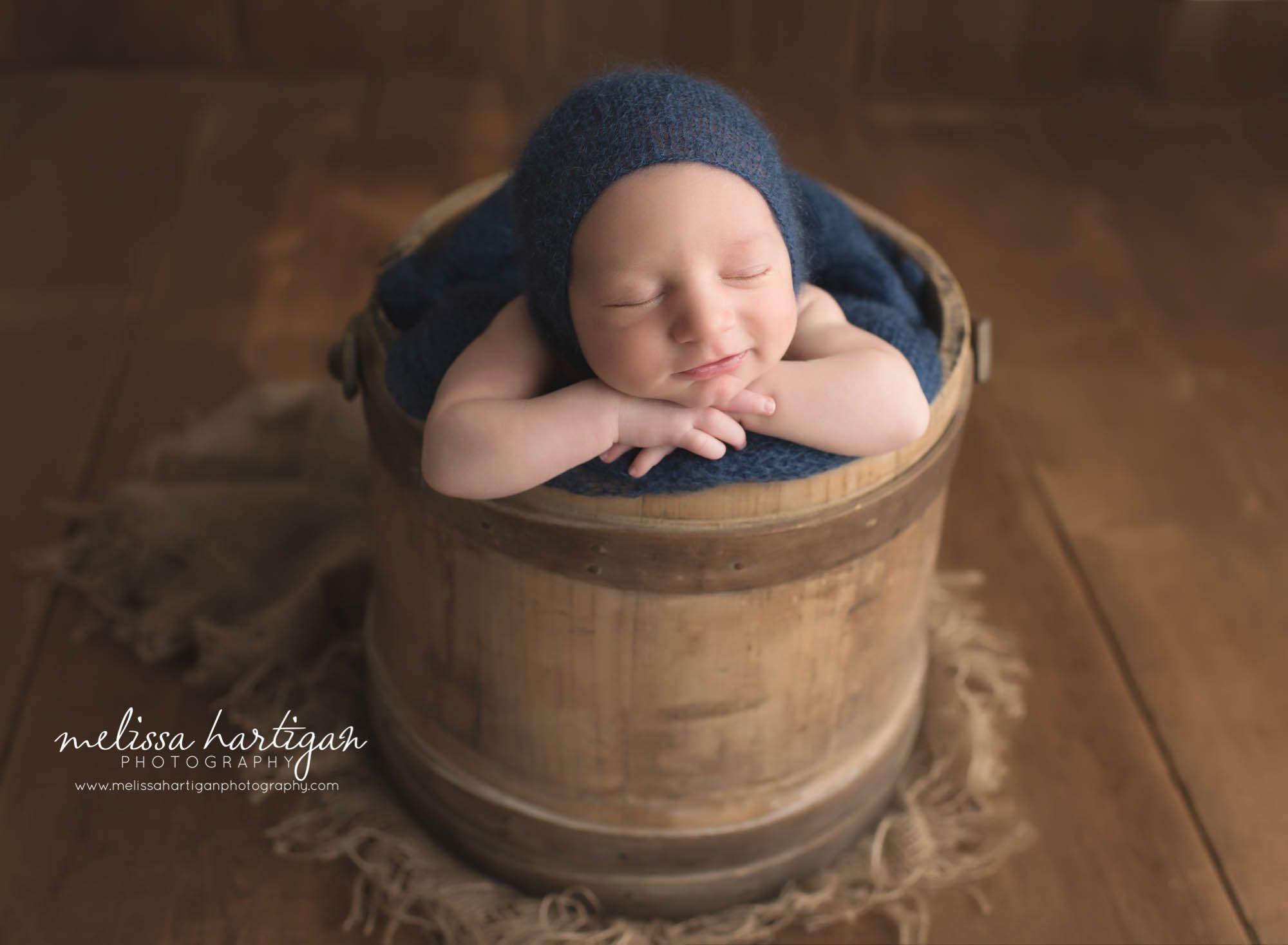 Newborn Photographer Connecticut newborn pose baby sleeping in wooden bucket