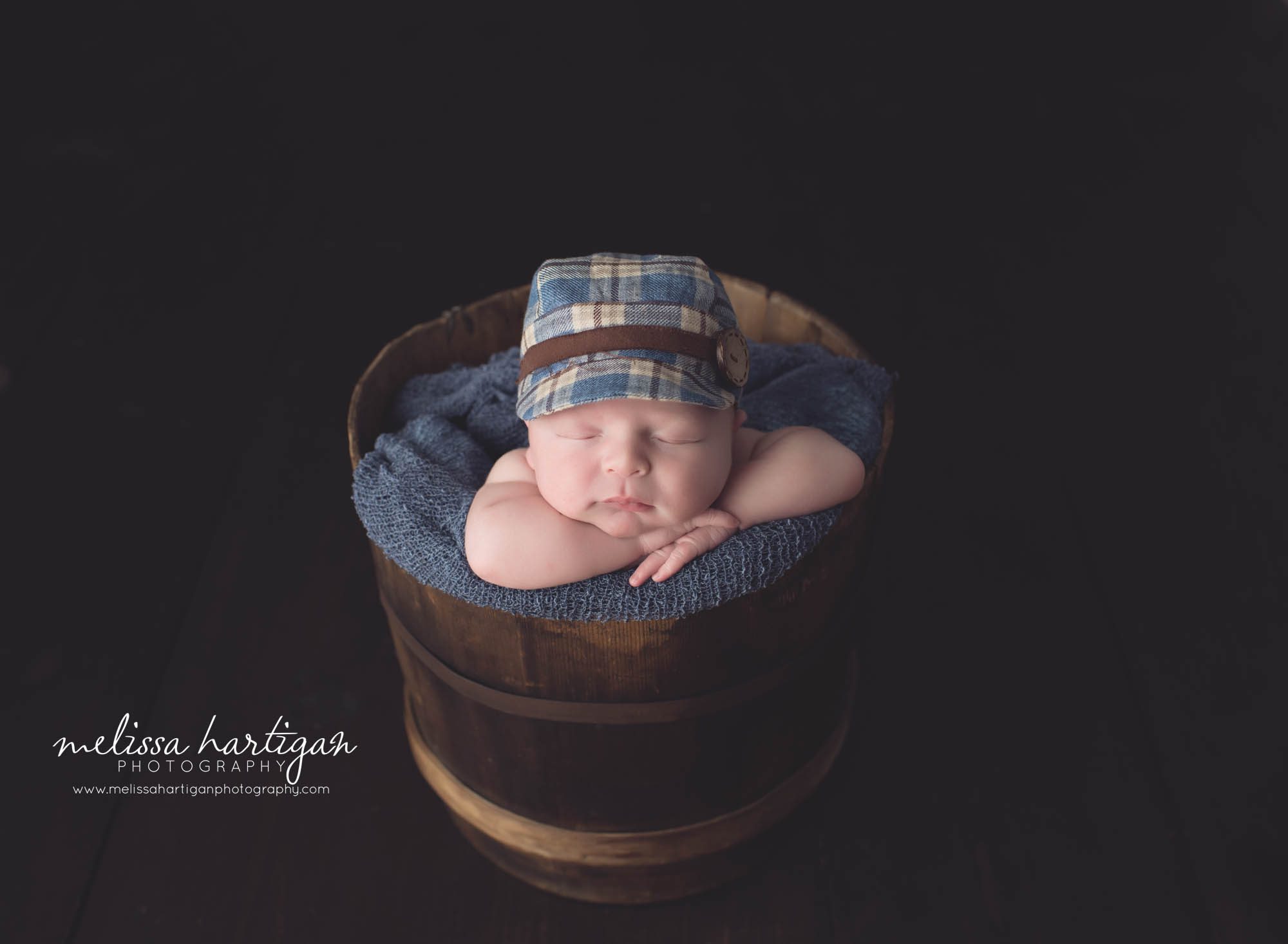 Newborn photographer CT newborn pose baby in barrel with plaid hat