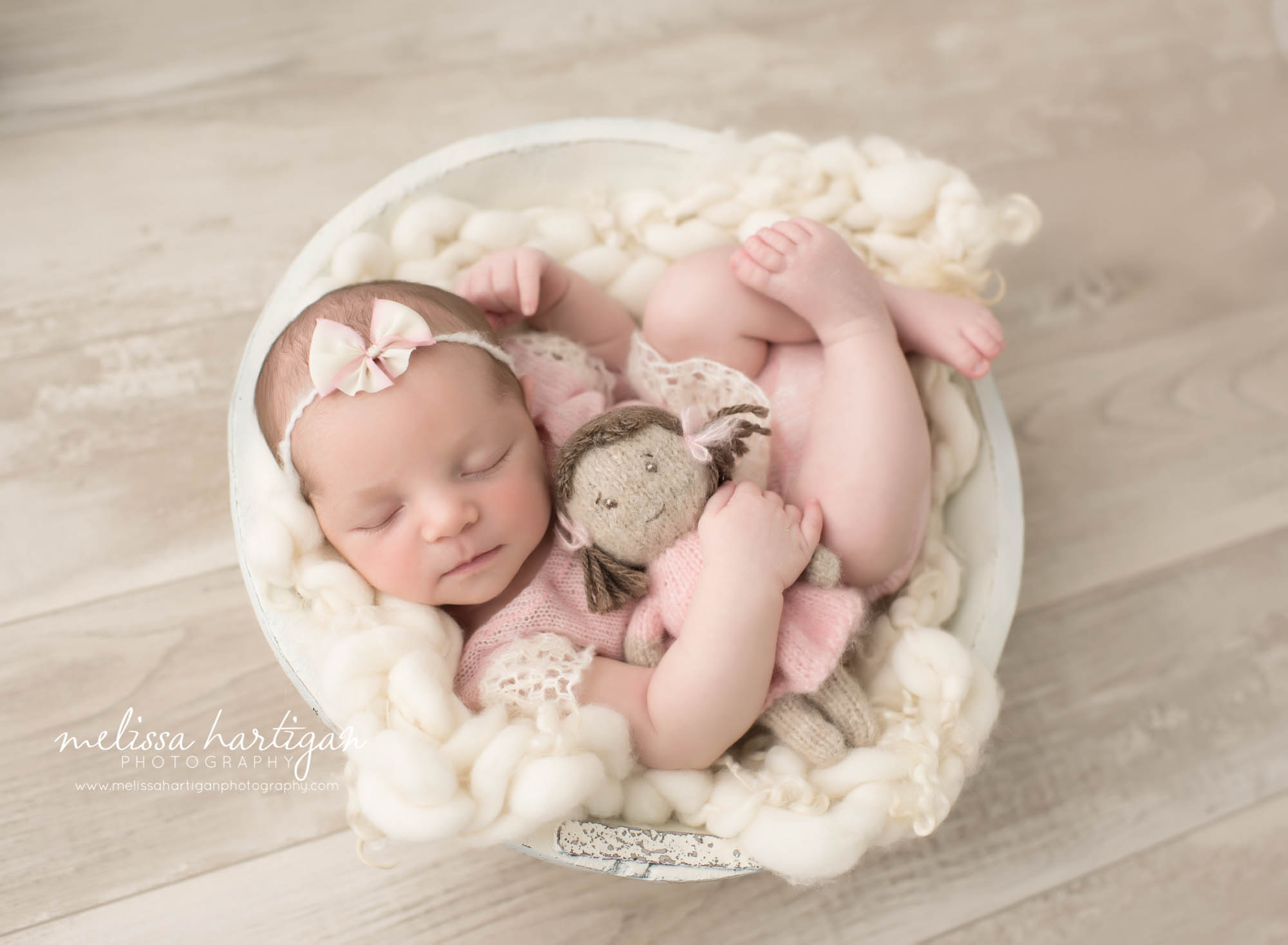 Connecticut Newborn Photographer baby holding doll sleeping in bowl