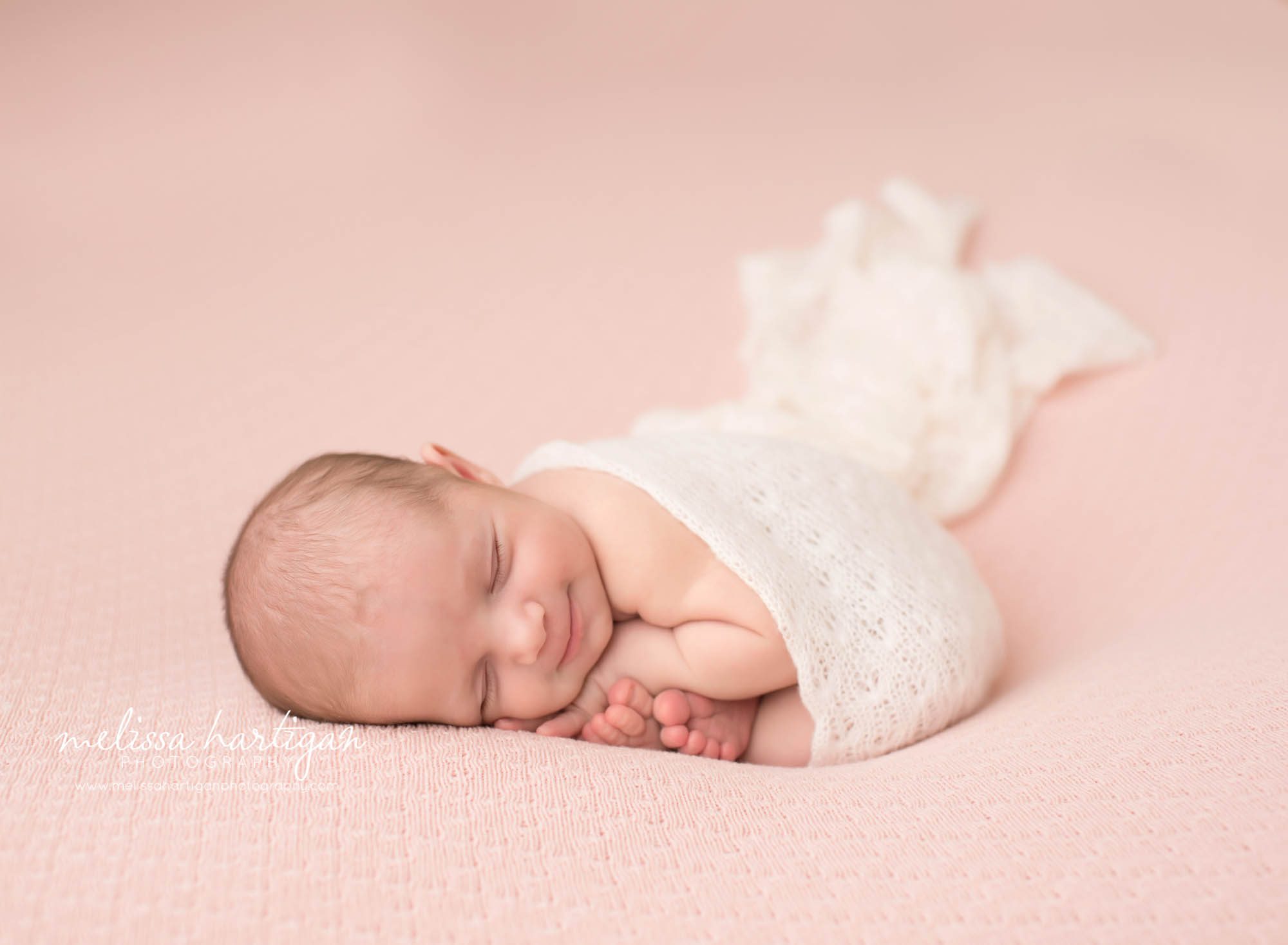 Connecticut Newborn Photographer baby girl smiling on pink blanket