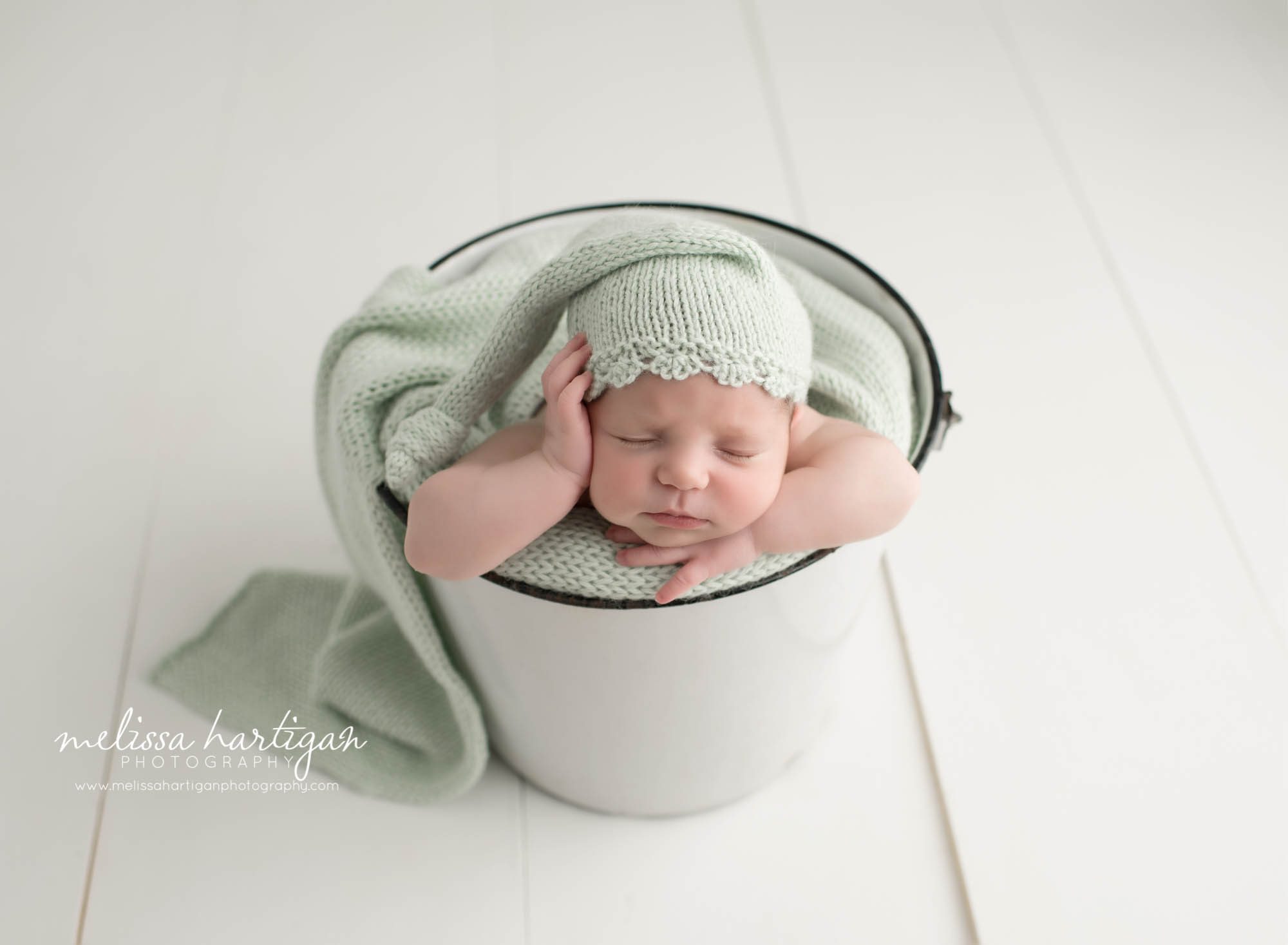 Connecticut Newborn Photographer baby in bucket with green hat