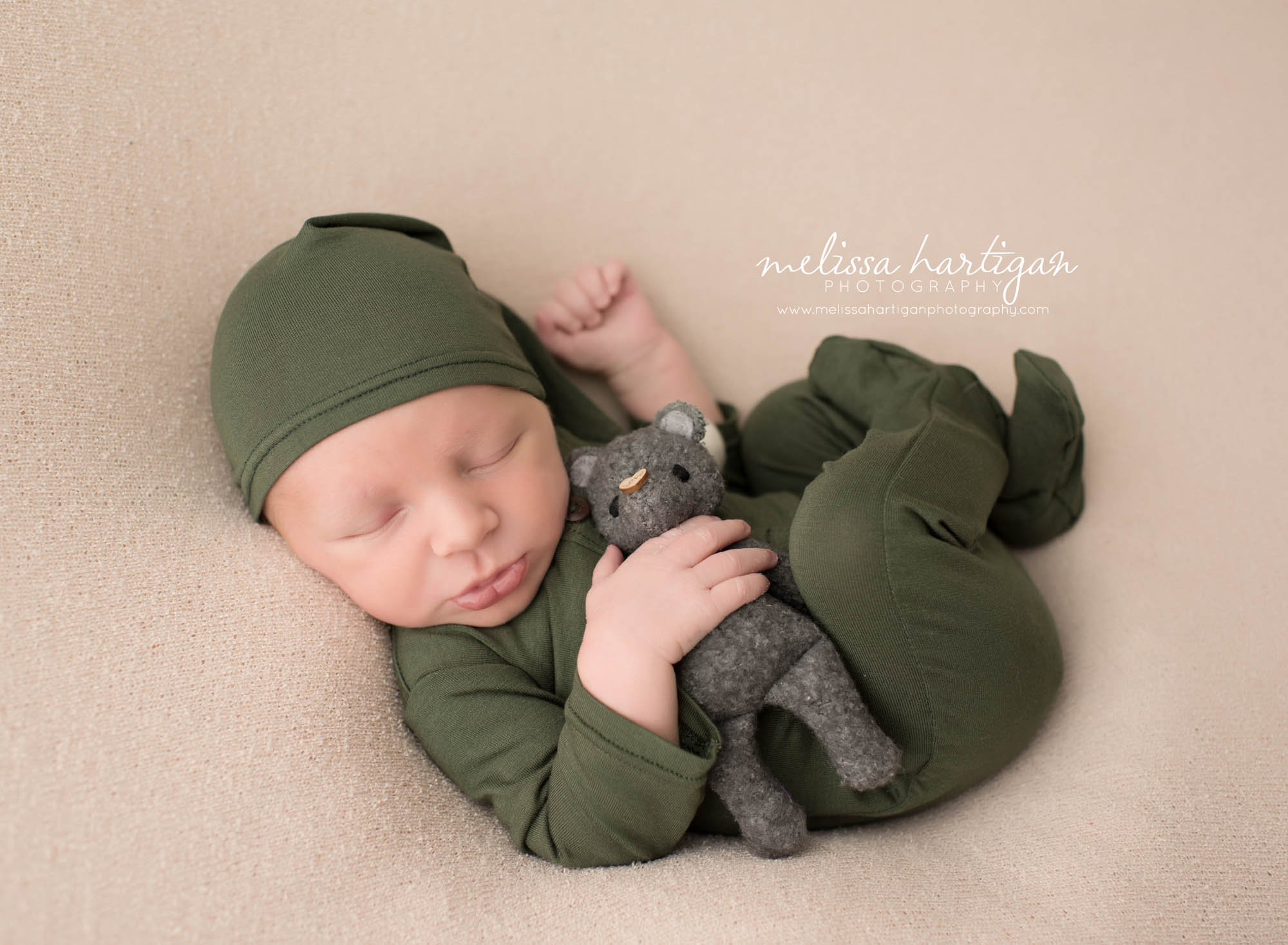 CT Baby Photography neworn boy in green outfit and hat holding stuffed animal