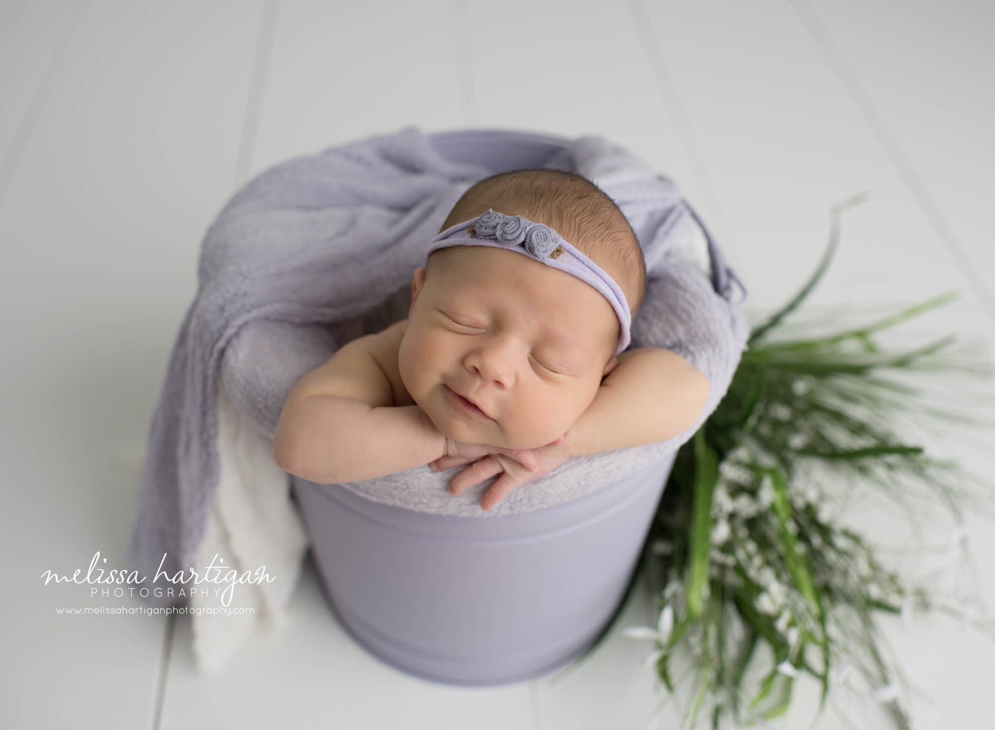 baby girl posed in muted lavender bucket with light lavender wrap maternity and newborn photographers in CT